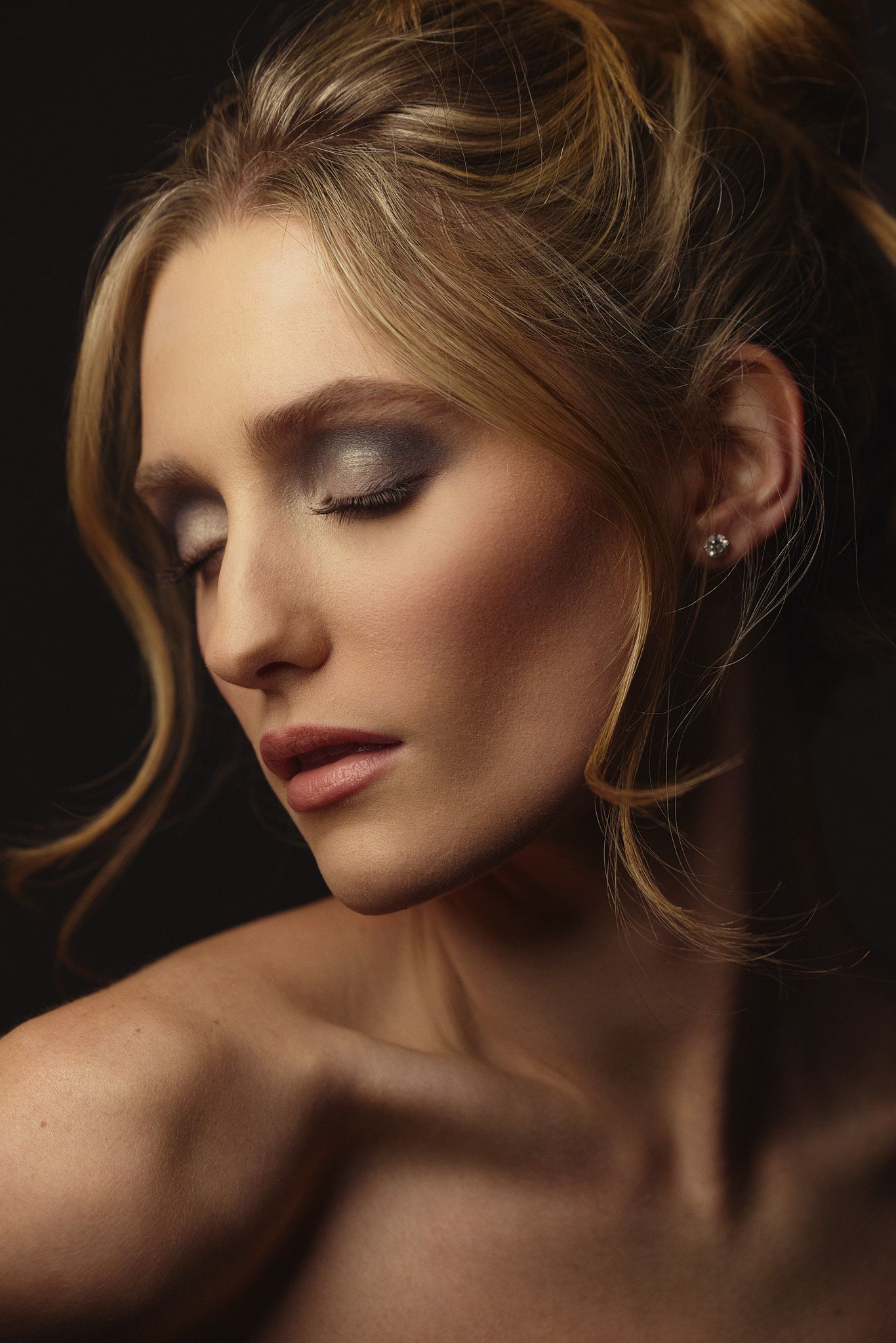 Artistic beauty portrait with soft lighting showing graceful neck and shoulder poses against dark background.