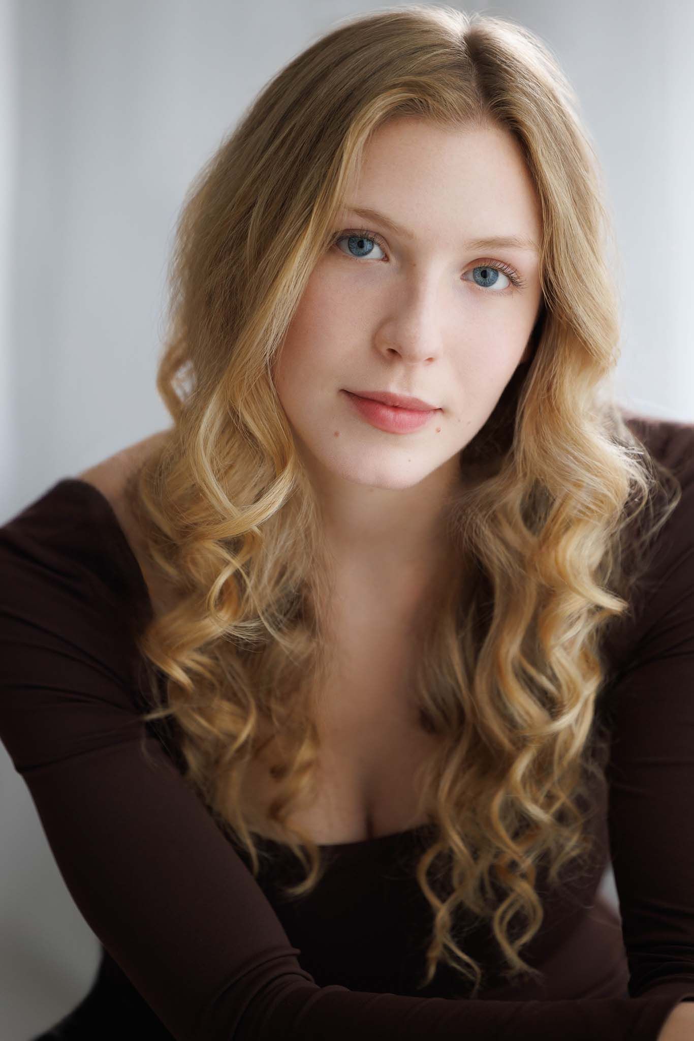 Soft portrait series with wavy hair against white background.