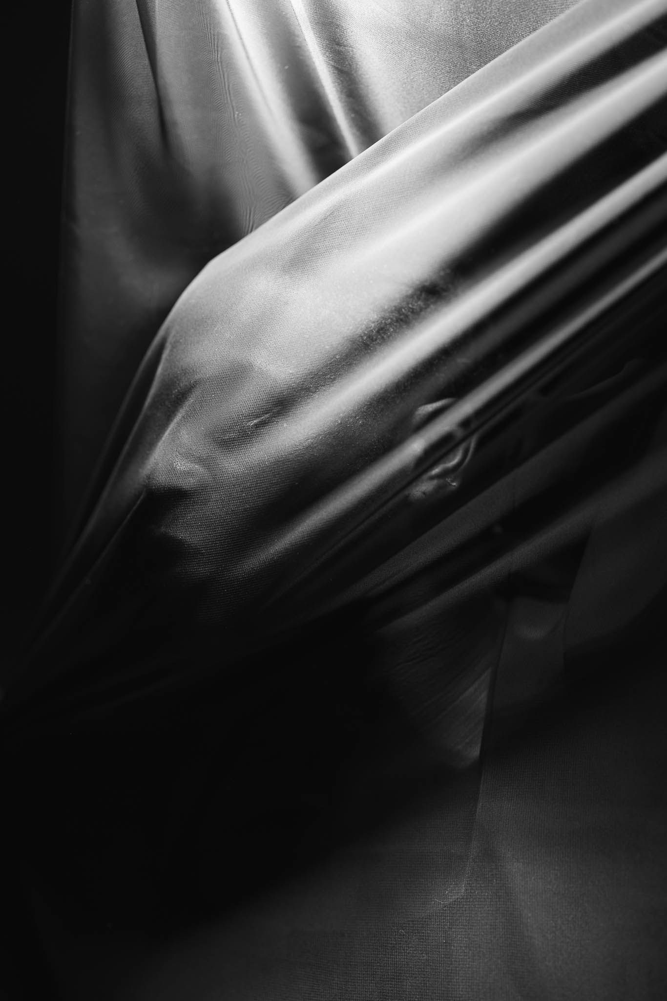 Abstract black and white photograph showing draped fabric with dramatic lighting and shadows.