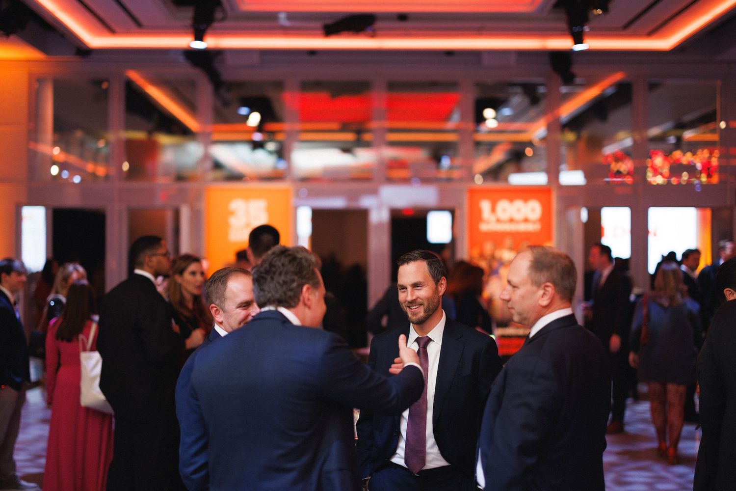 Business networking event in a modern venue with warm lighting and professional atmosphere.
