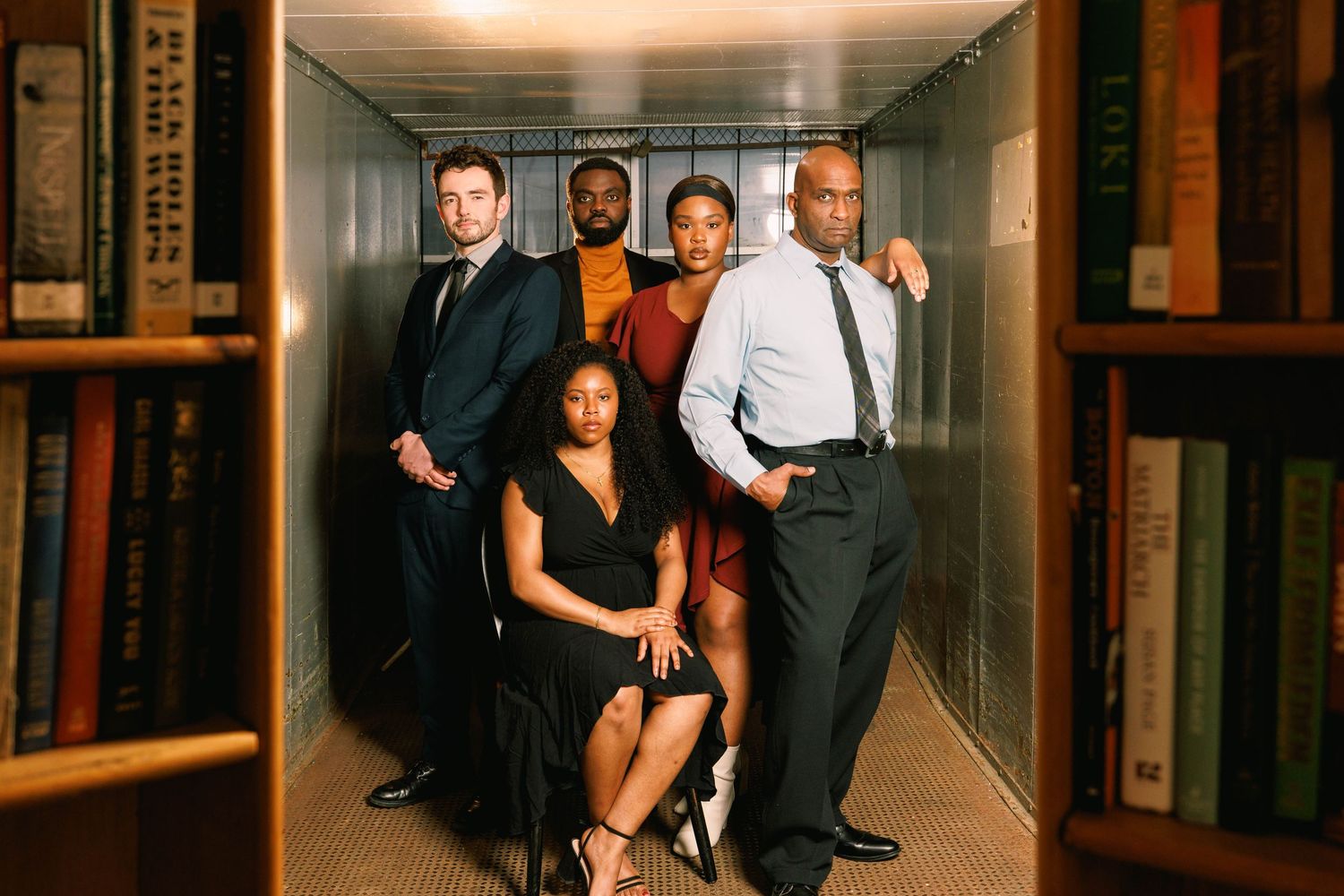 Professional group photo of a diverse ensemble posed in a stylish hallway setting.