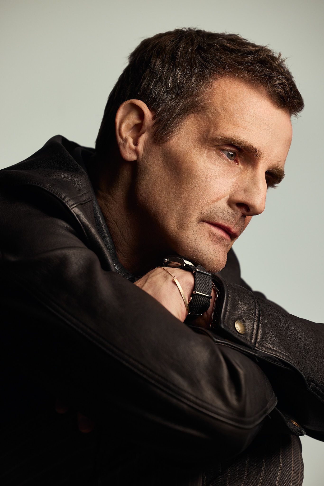 A series of dramatic profile shots showing someone wearing a dark leather jacket against a light background.