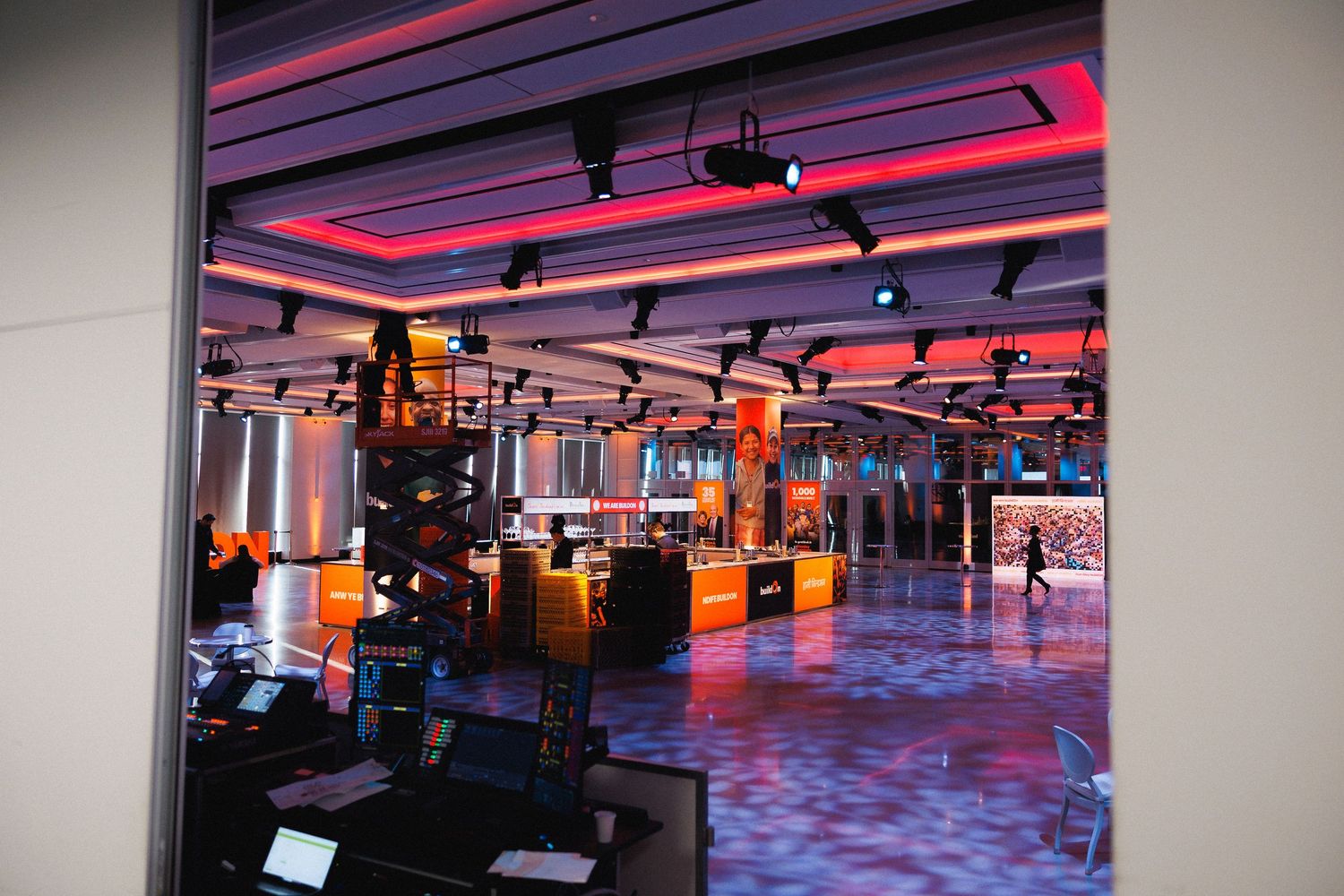 Professional conference venue with modern lighting and sleek design features illuminated in purple and red tones.