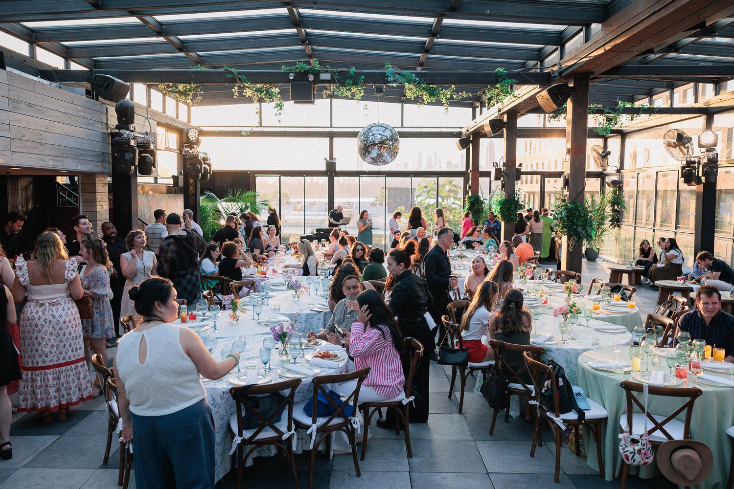 Outdoor covered patio dining area filled with guests at tables during a social gathering.