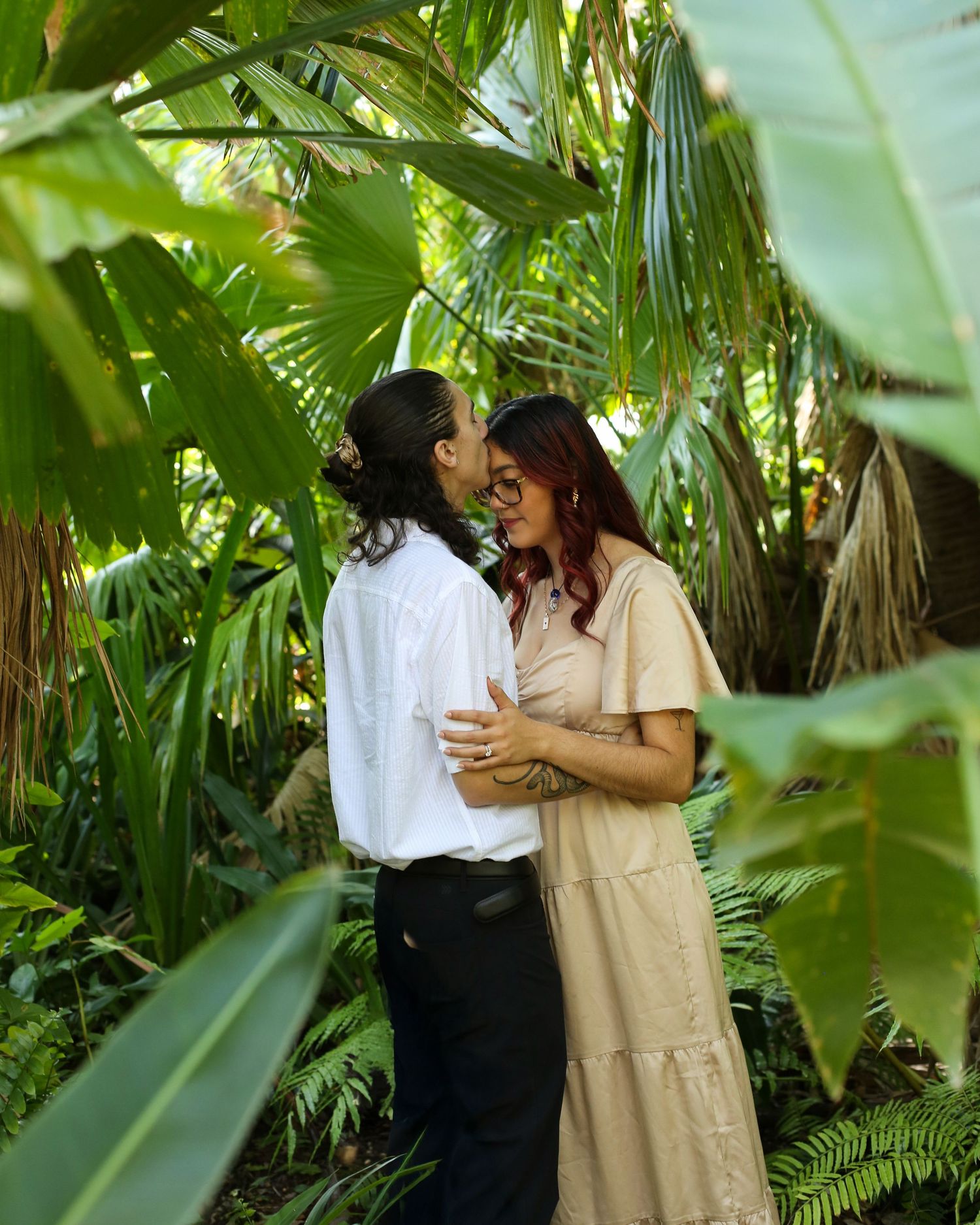 Engaged couple embrace in wooded area at Harry P. Leu Gardens in Florida.