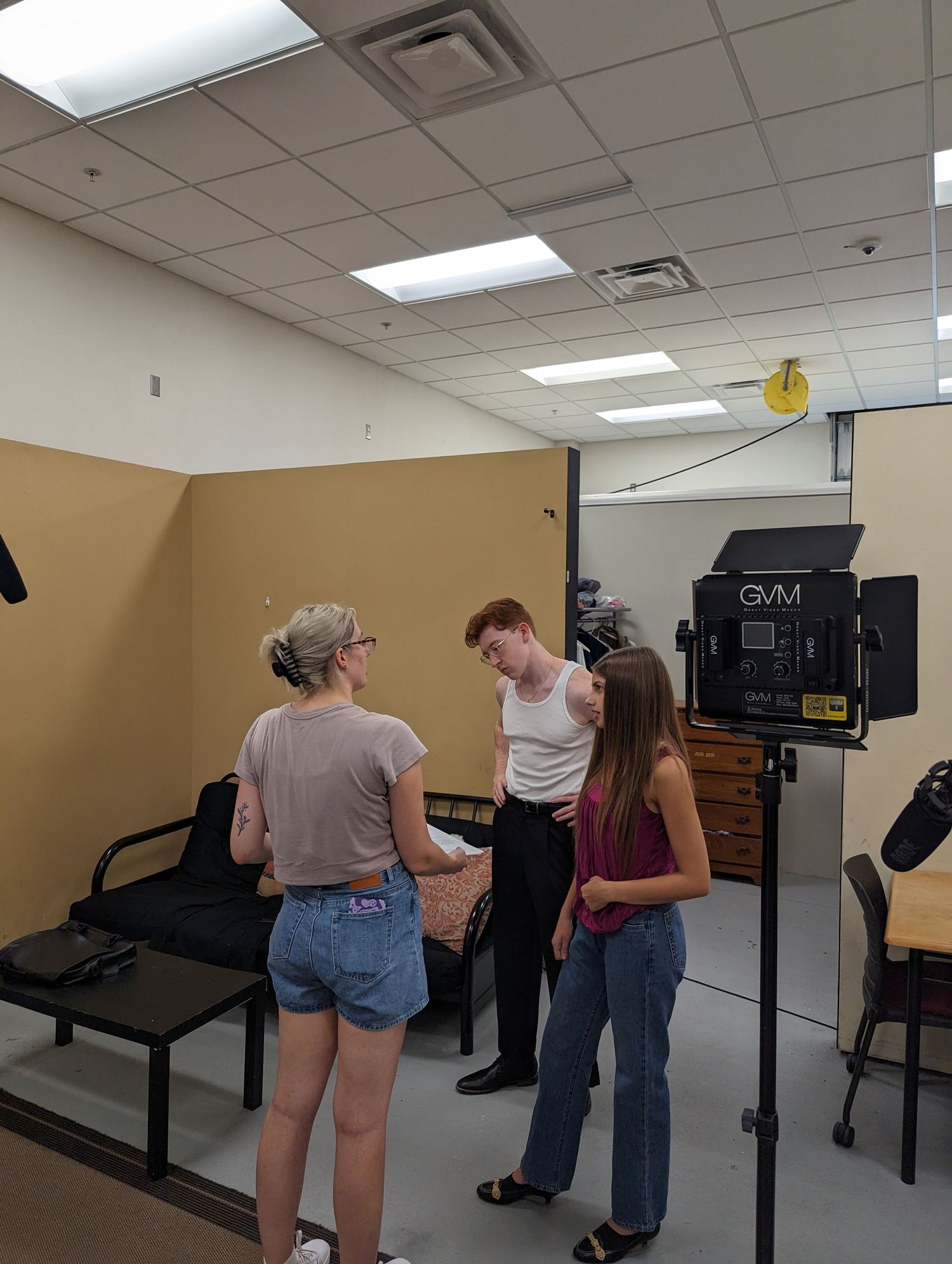 Behind the scenes film production setup with camera equipment in an indoor studio space.