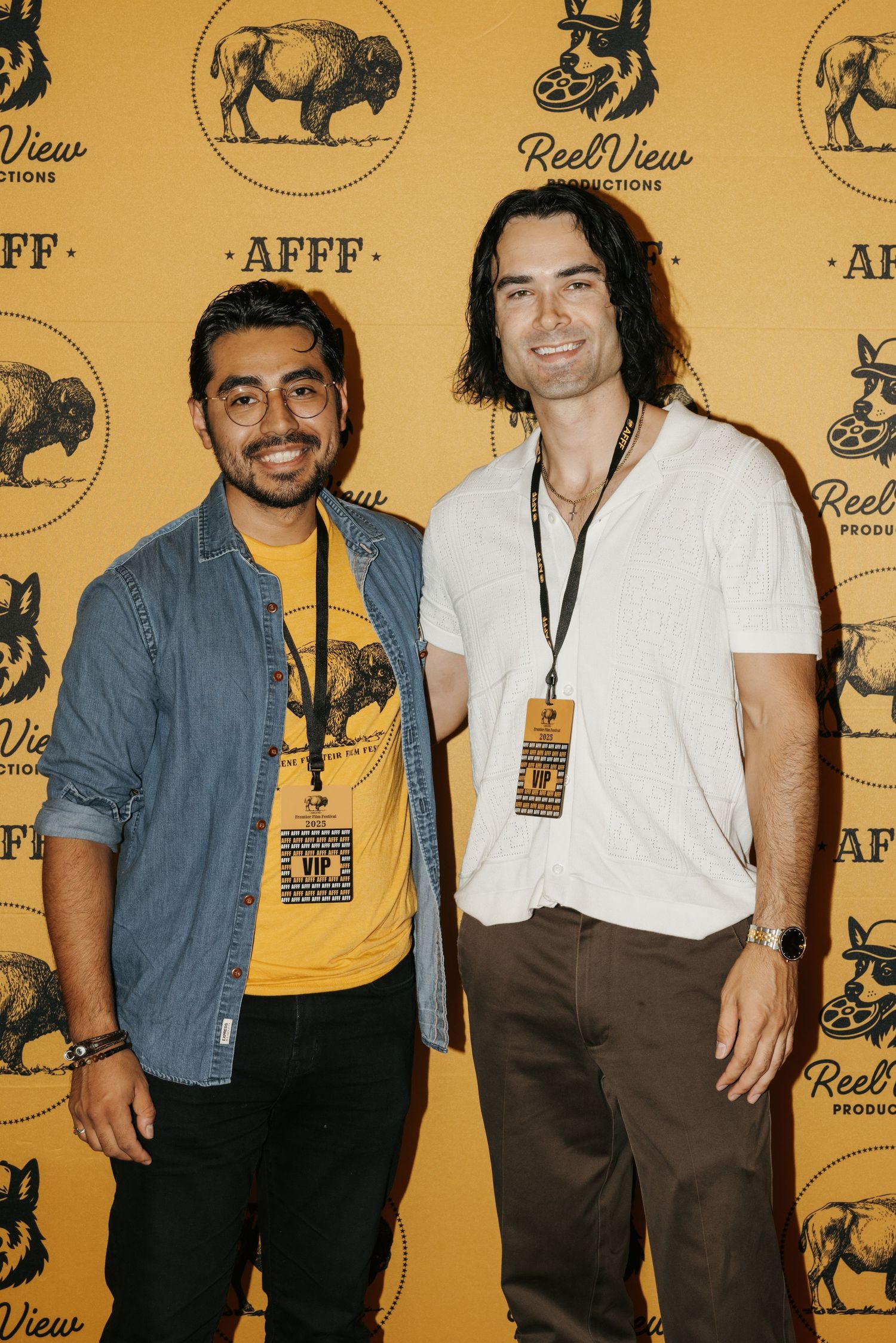 Musicians pose together at a media event with a yellow backdrop featuring buffalo logos and branding.