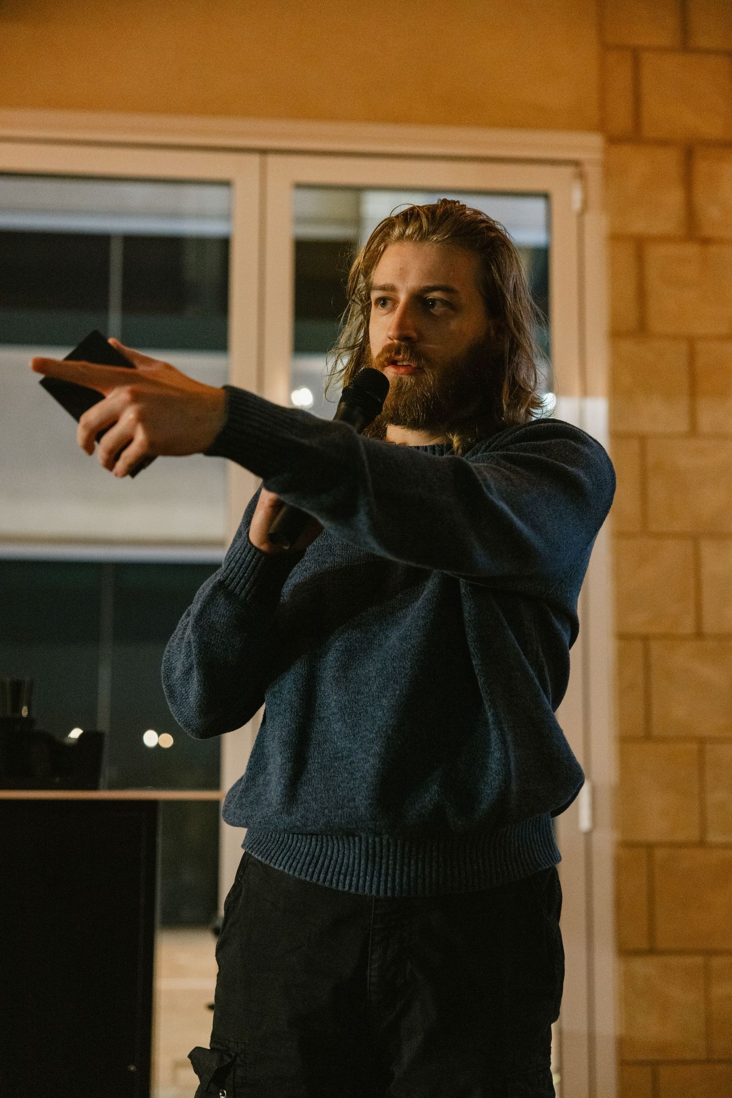 Person in navy blue sweater gestures animatedly in a sequence of photos against a warm-toned interior wall.
