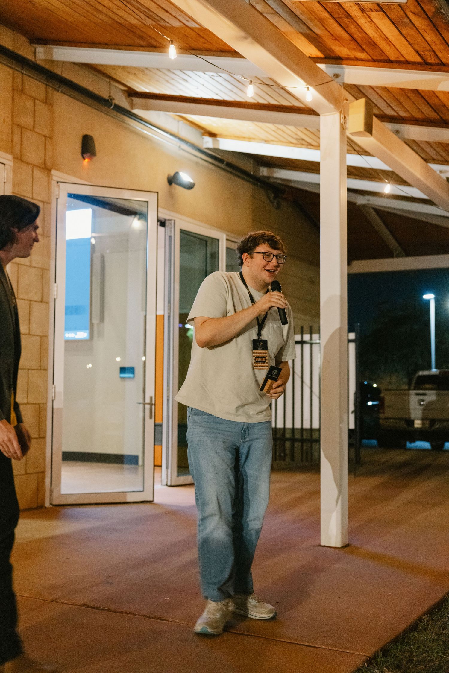 A sequence of photos showing a person in casual attire walking through a covered outdoor walkway at night.