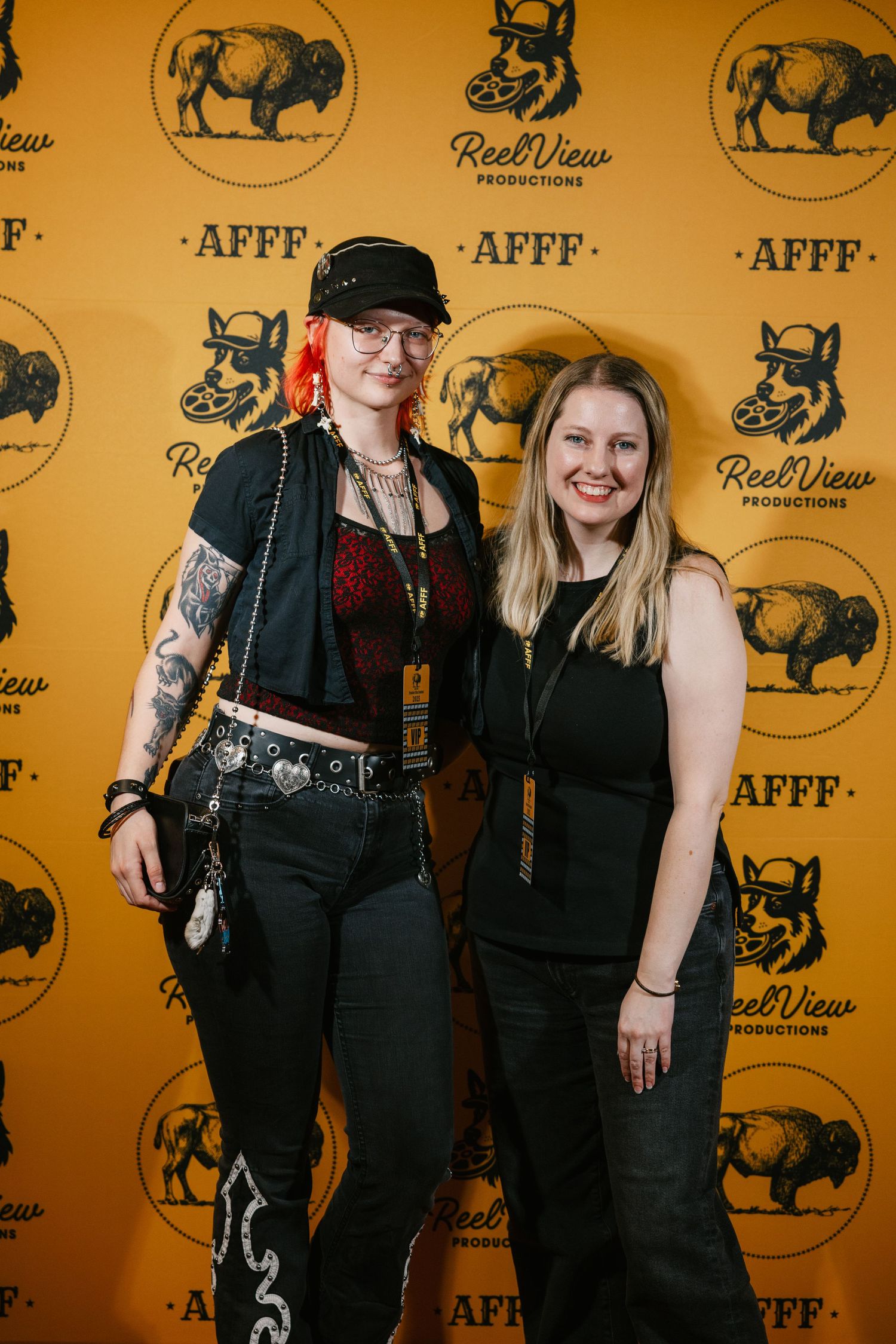 People in black outfits pose against a yellow backdrop with buffalo logo branding at a formal event.