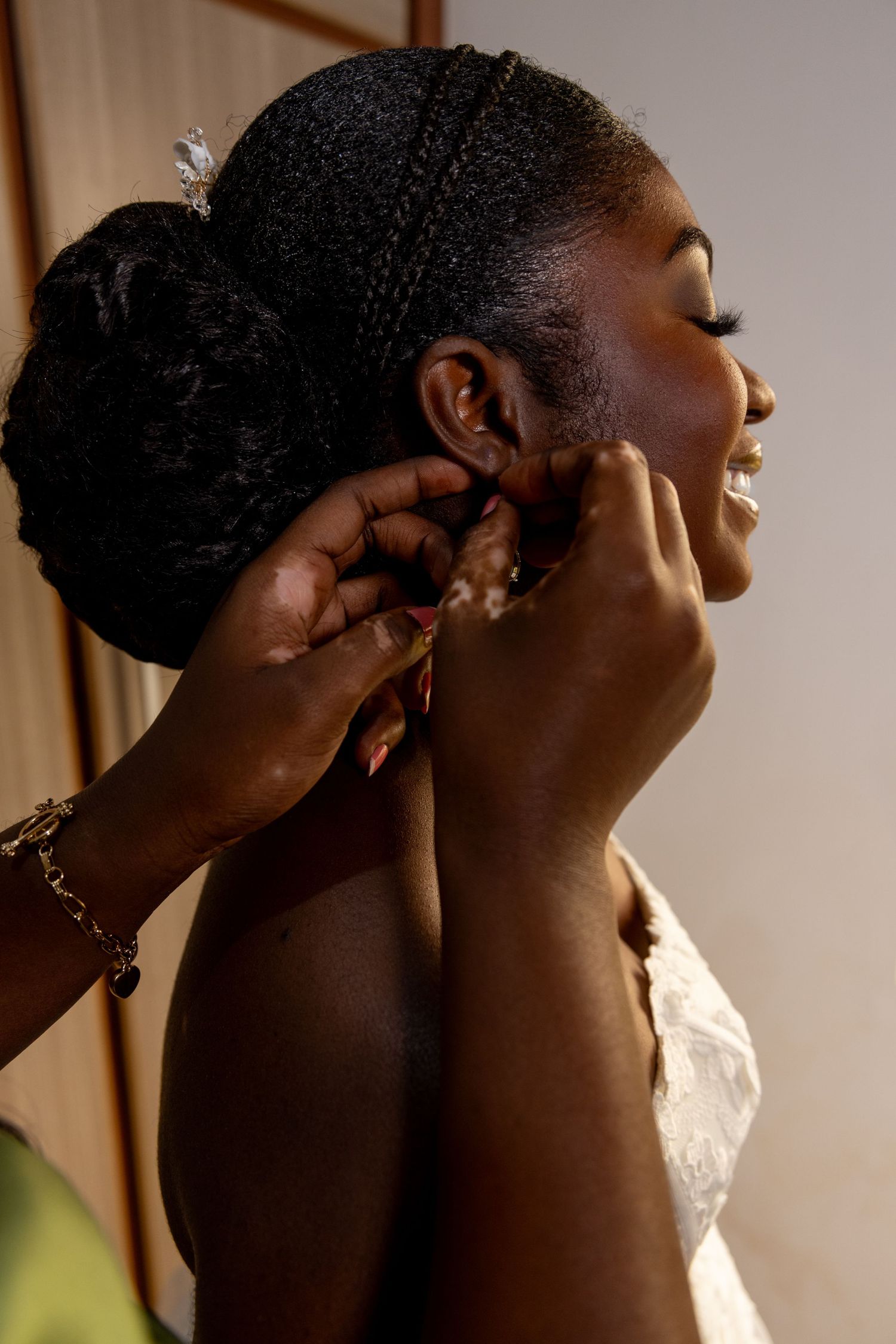 Close-up of bride’s hands fasteningher gown before wedding