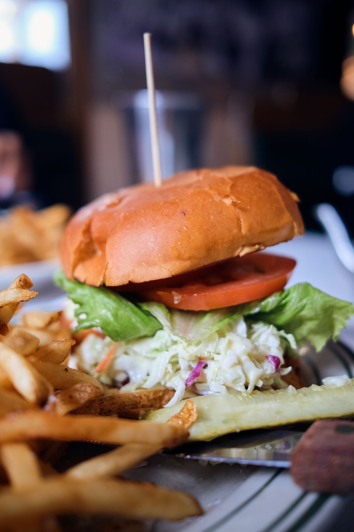 Fresh hamburger with lettuce, tomato and shredded cabbage served with crispy french fries.
