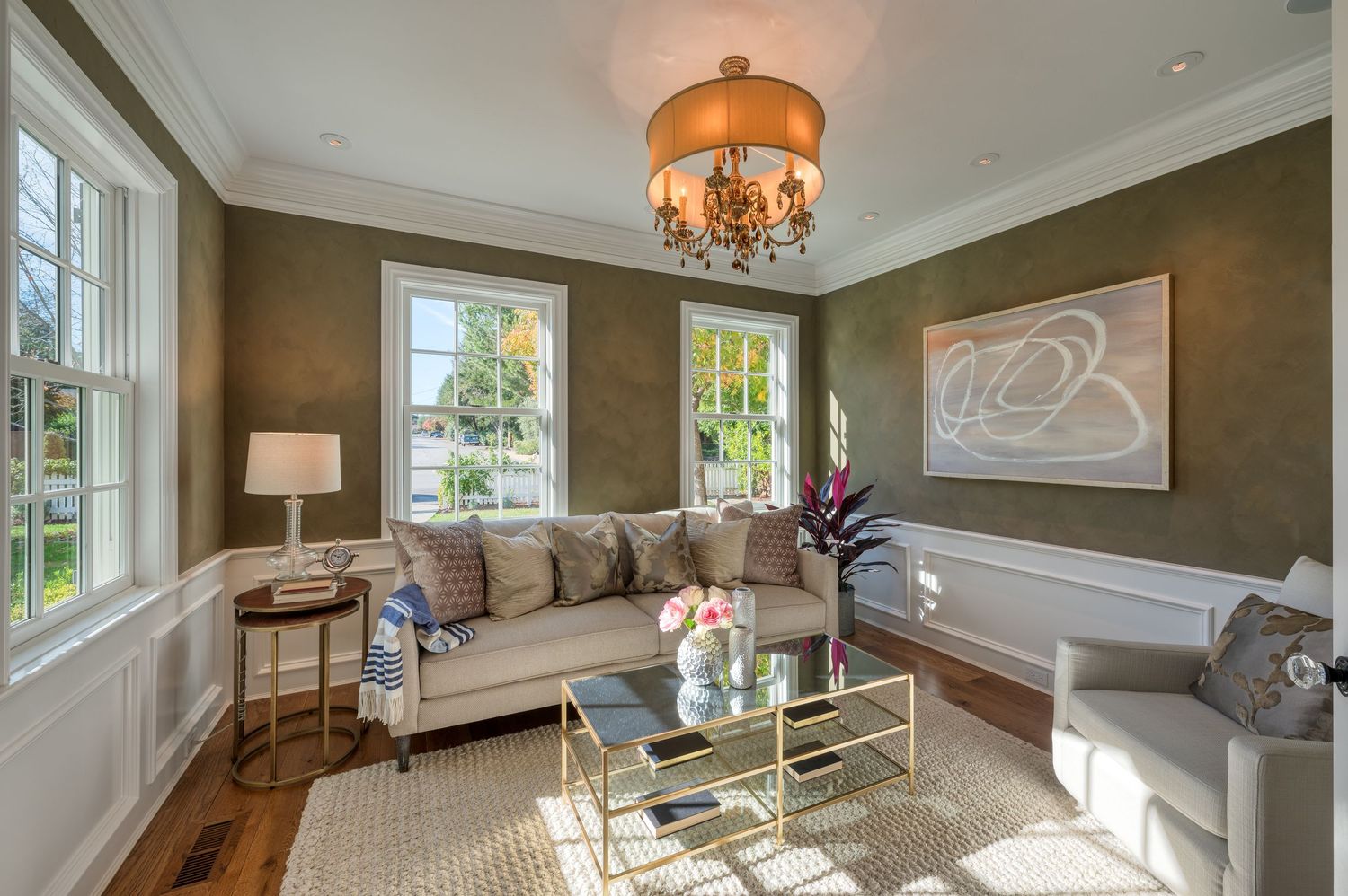 Contemporary sitting room with brown wallpaper, glass coffee table, and geometric wall art.