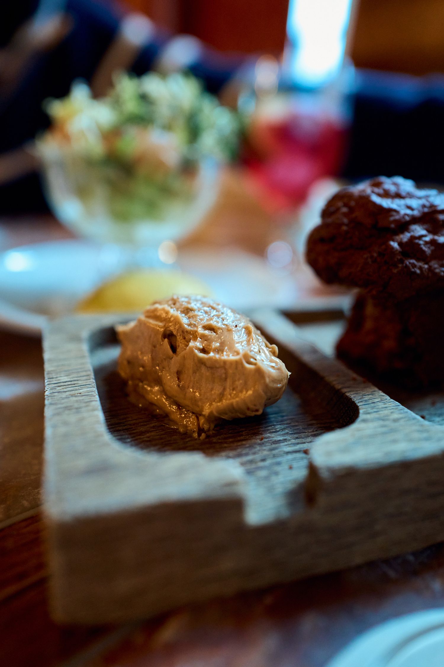 Close-up of chocolate mousse and dessert served on a rustic wooden platter.