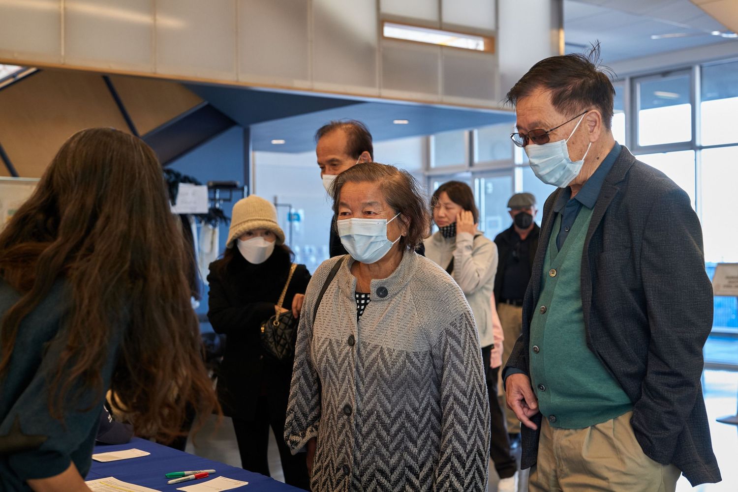 Group gathering at indoor event with people wearing face masks.