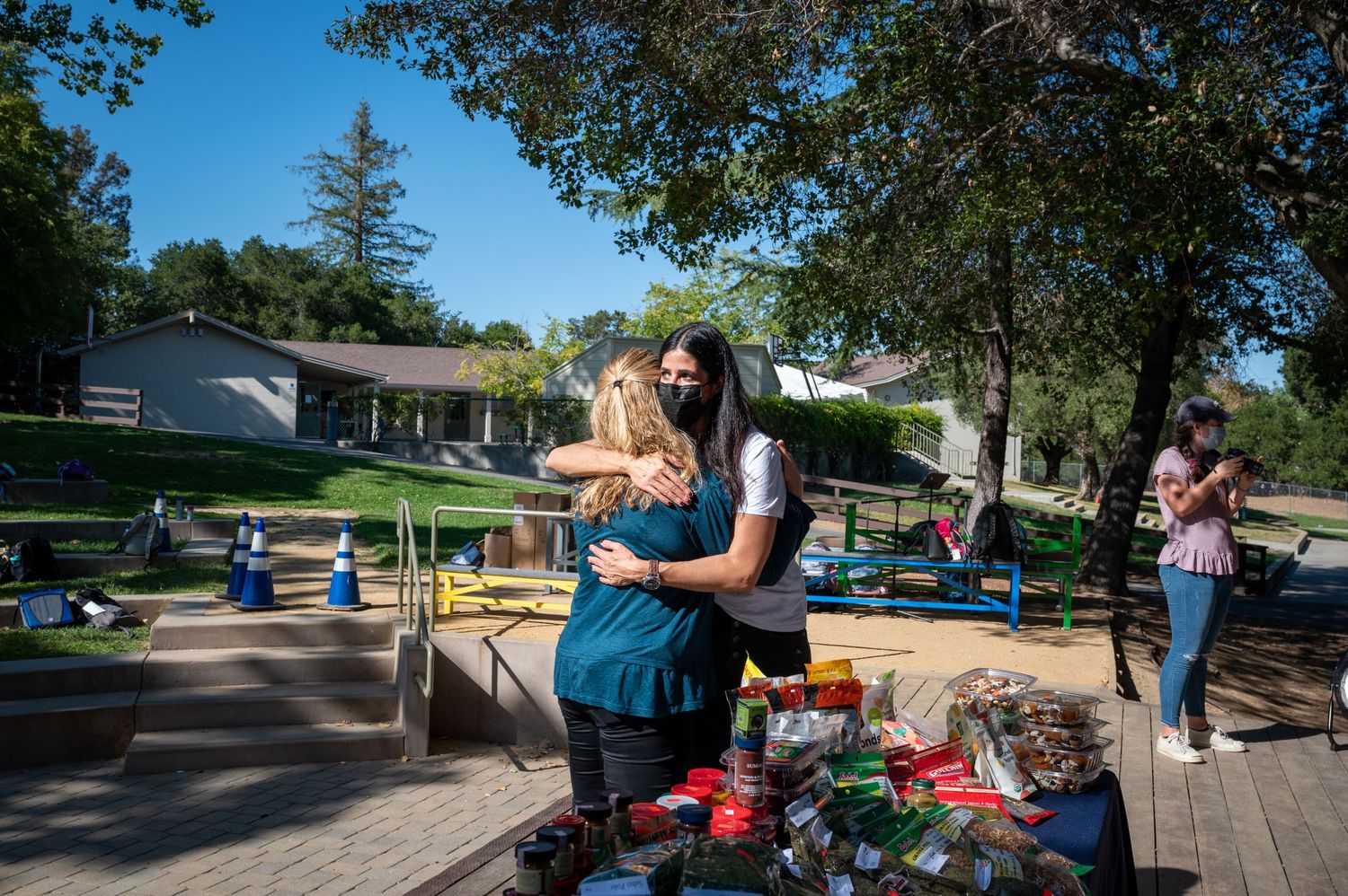 People interact at outdoor tables set up for a community event.