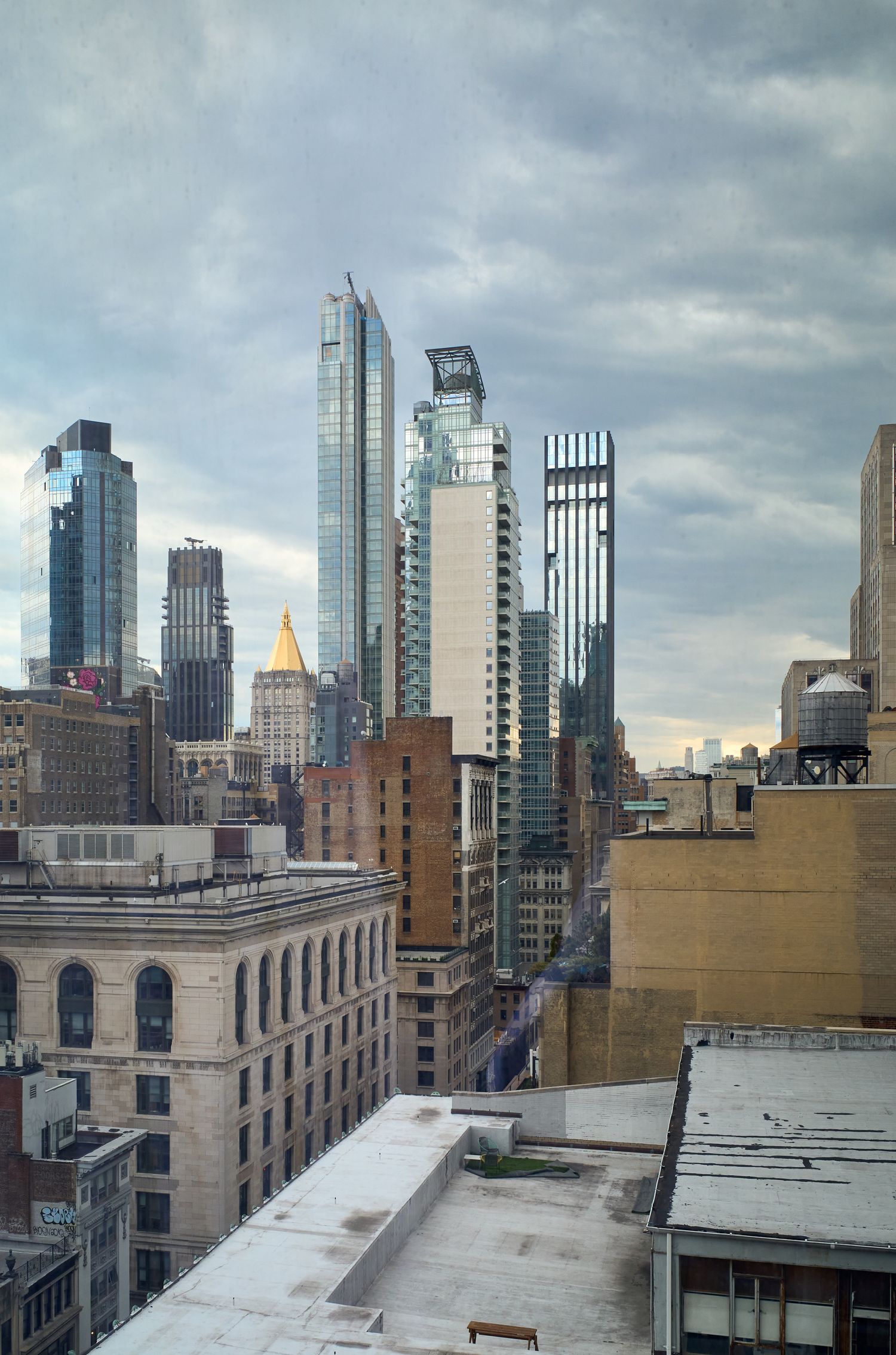 Manhattan skyline view with modern skyscrapers against cloudy sky.