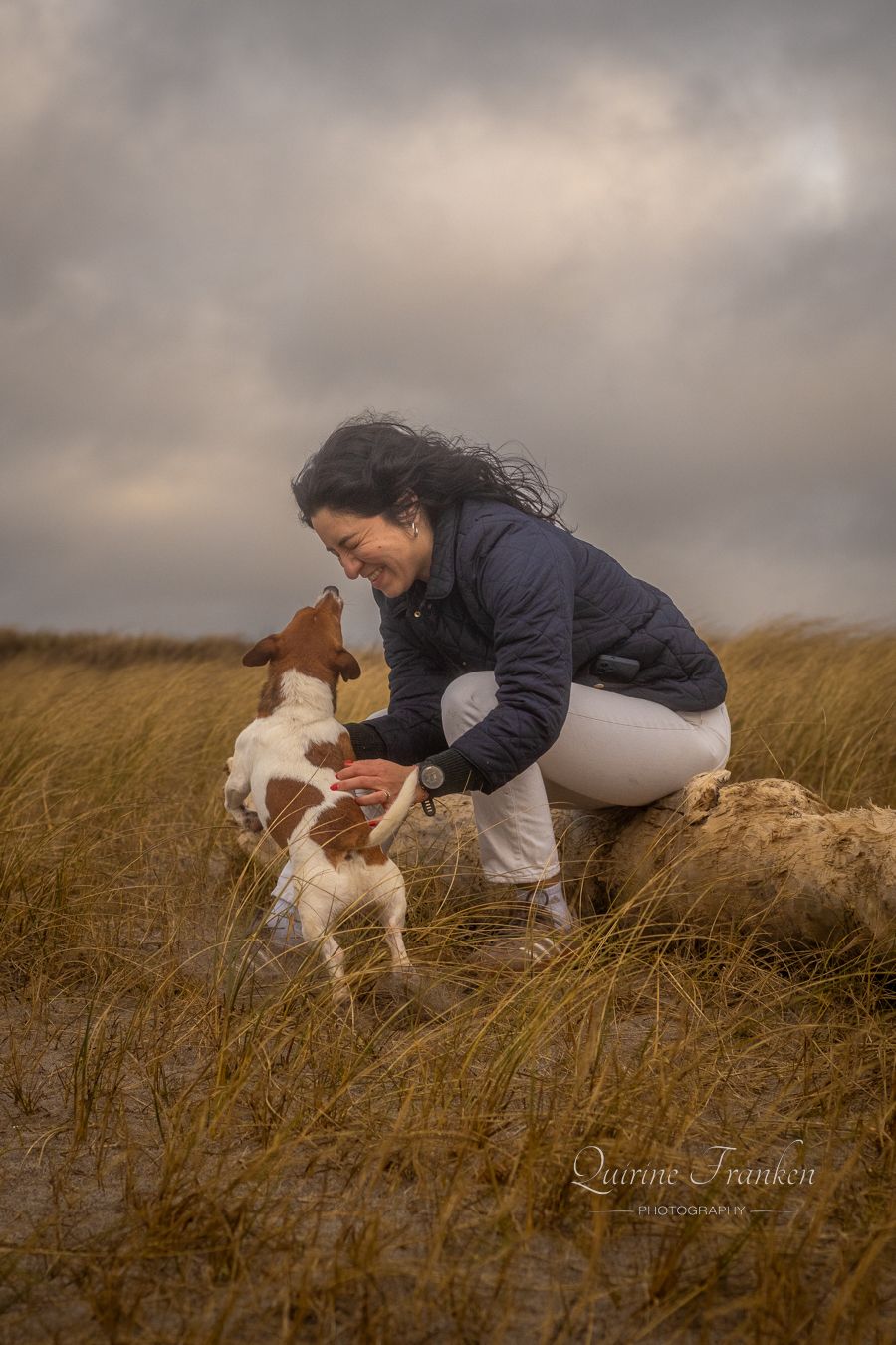 Dog and owner playing together at the beach during photoshoot