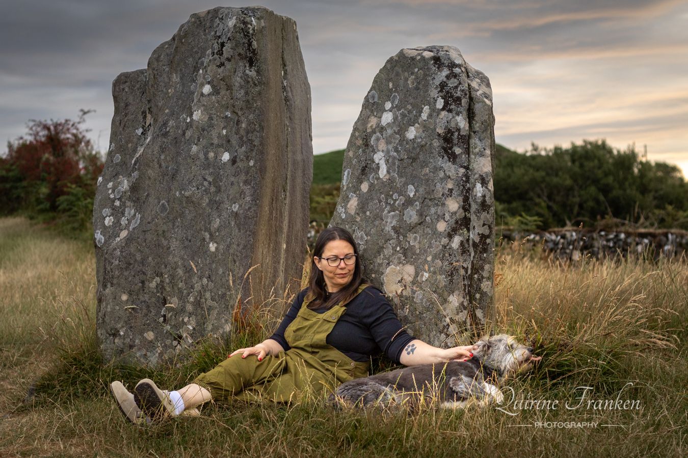 Dog and owner sitting at the big stones of Drombeg Stone Circle in West Cork