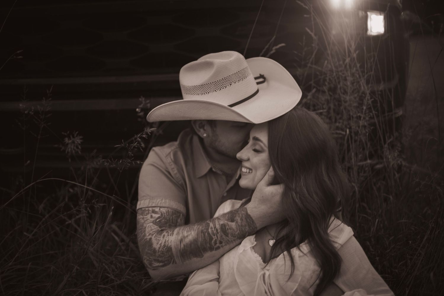 A romantic black and white photo series shows a couple embracing and sharing tender moments in a rustic outdoor setting.