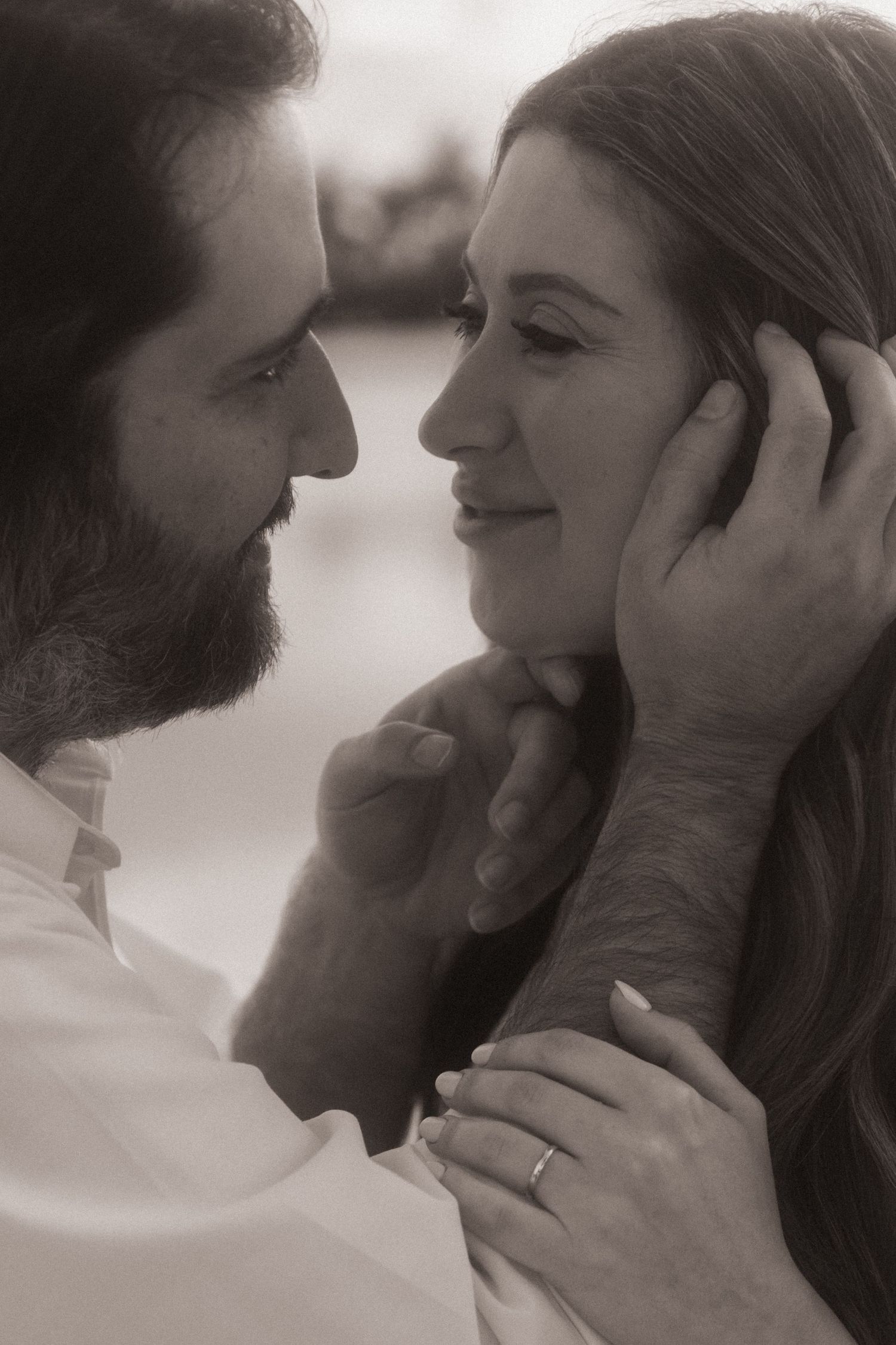A romantic black and white photo sequence showing a tender moment between a couple gazing at each other.