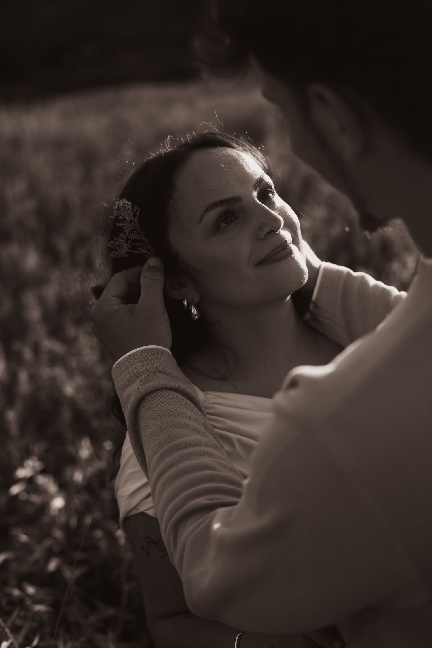 A series of black and white portraits showing a person in a white sweater lying down with dramatic lighting and shadows.