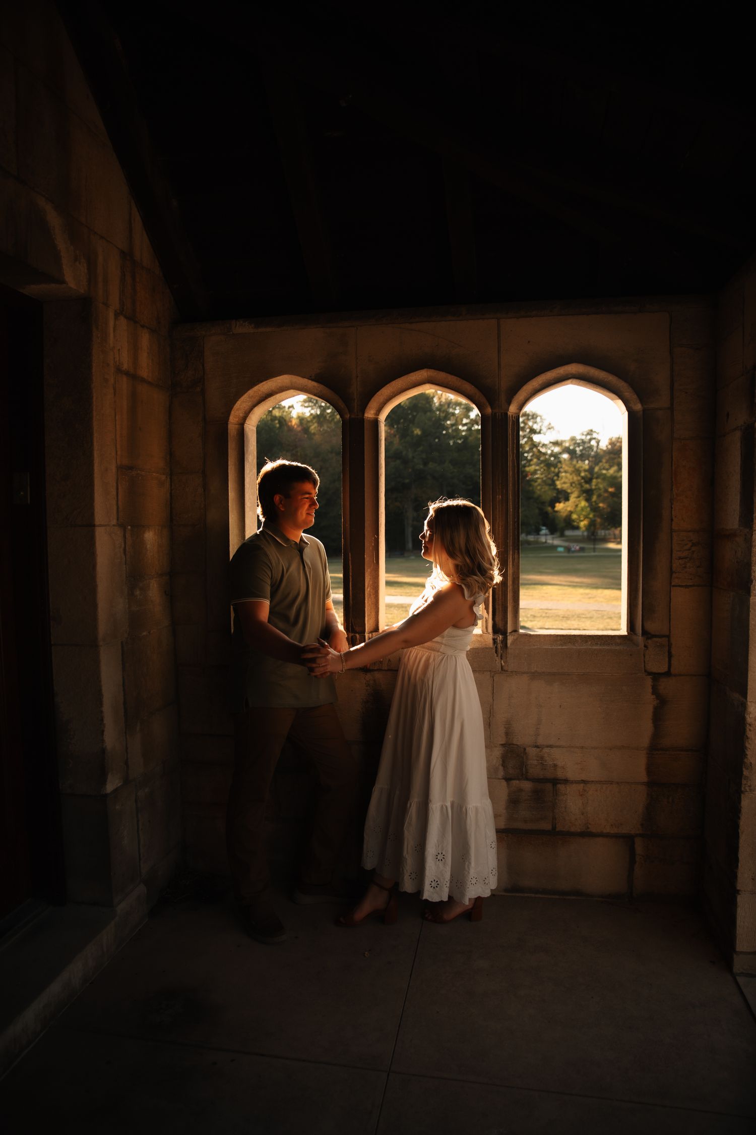 A series of five moody, atmospheric shots showing silhouettes in a stone hallway with sunlit arched windows.