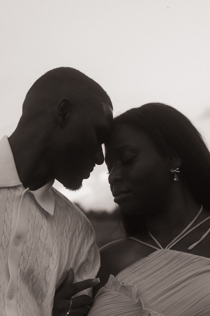 Black and white portrait of a romantic couple touching foreheads in an intimate and tender moment.