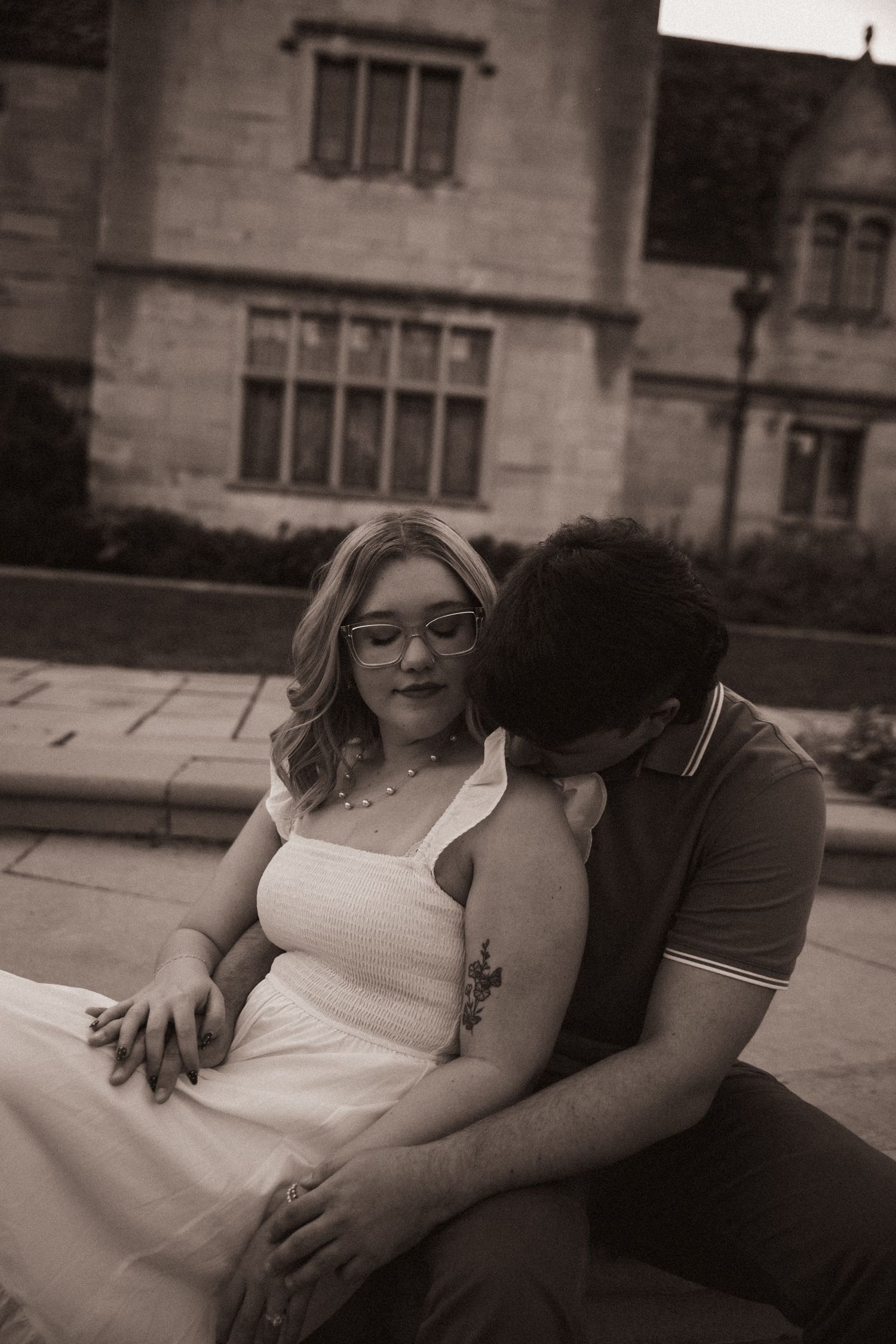 Couple relaxing on stone steps during an intimate engagement photography session.