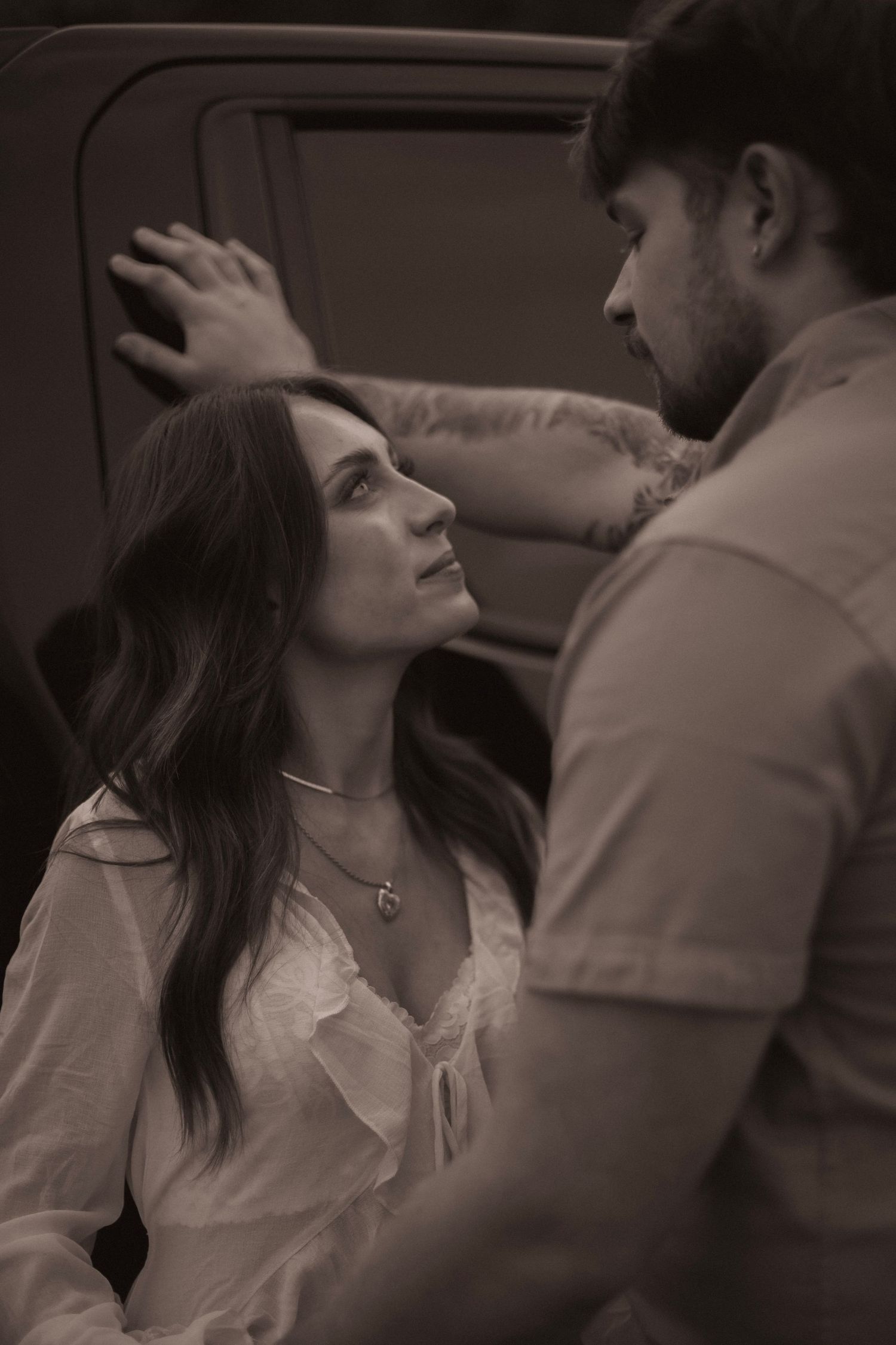 A romantic sepia-toned sequence showing an intimate moment between a couple in a vintage style setting.