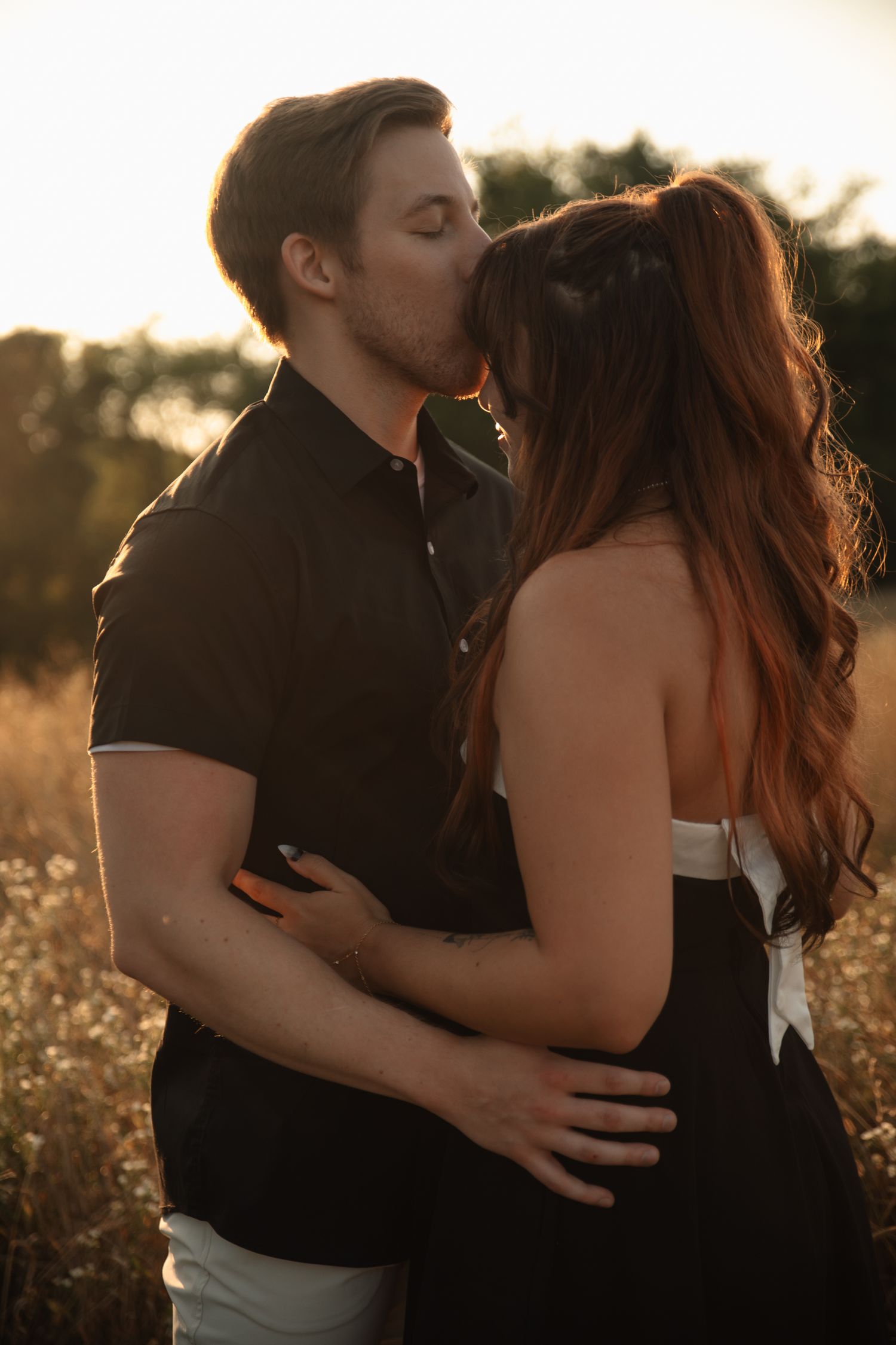 A romantic couple embraces in a golden sunlit field during sunset, creating a series of intimate silhouettes.