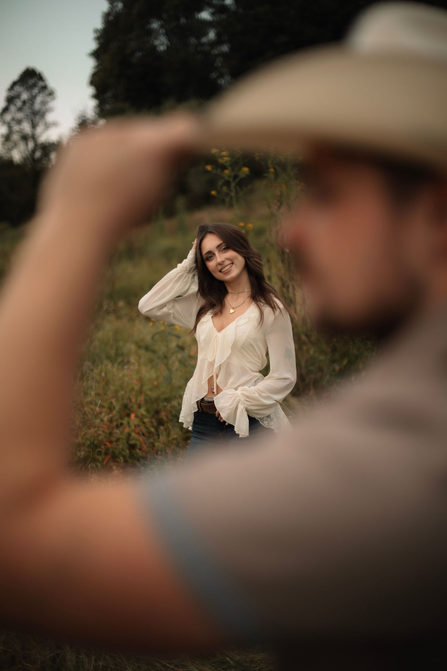 A series of candid outdoor portrait shots showing joyful expressions in a natural field setting at golden hour.