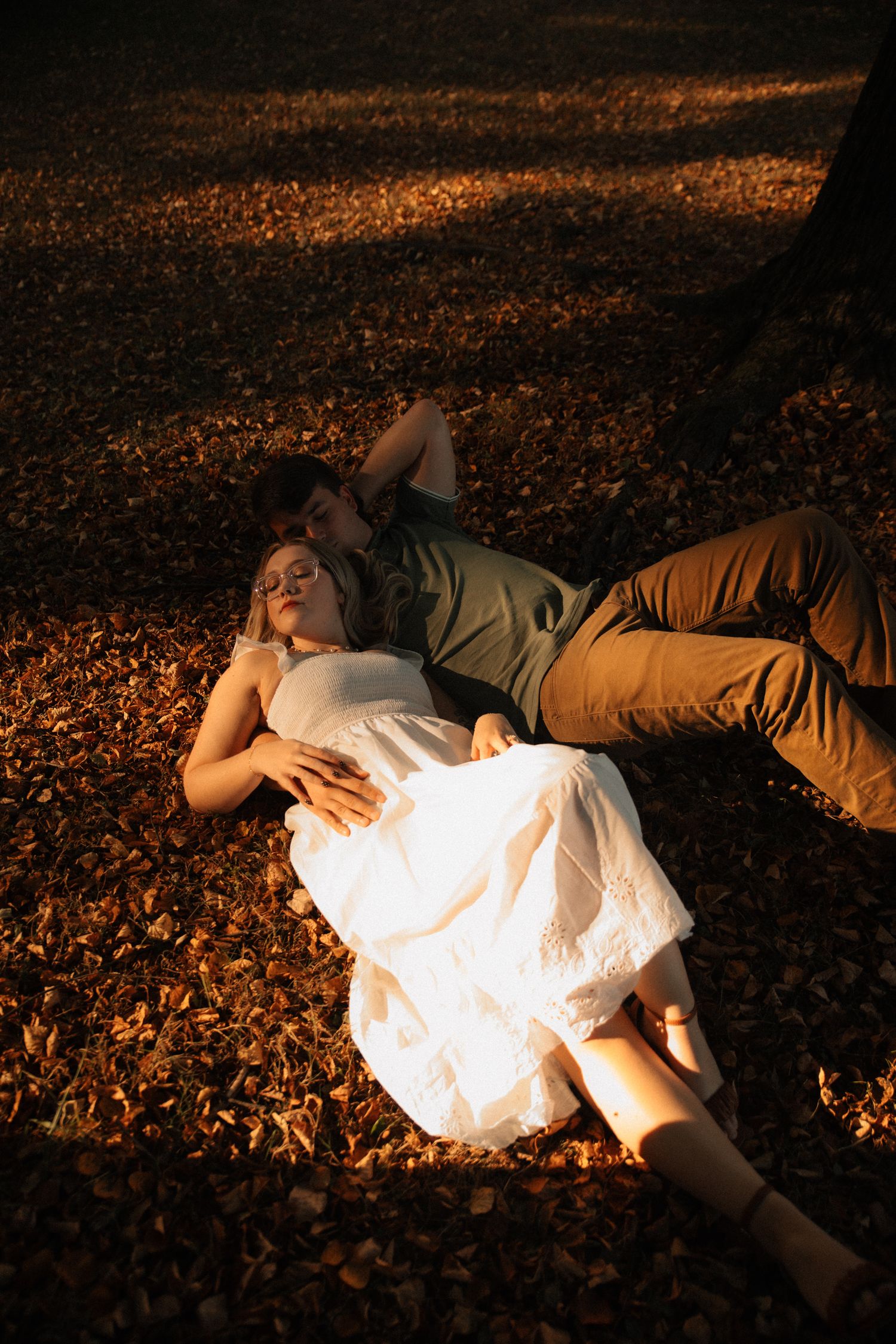 A sequence showing a couple lying in autumn leaves with dramatic lighting and shadows.