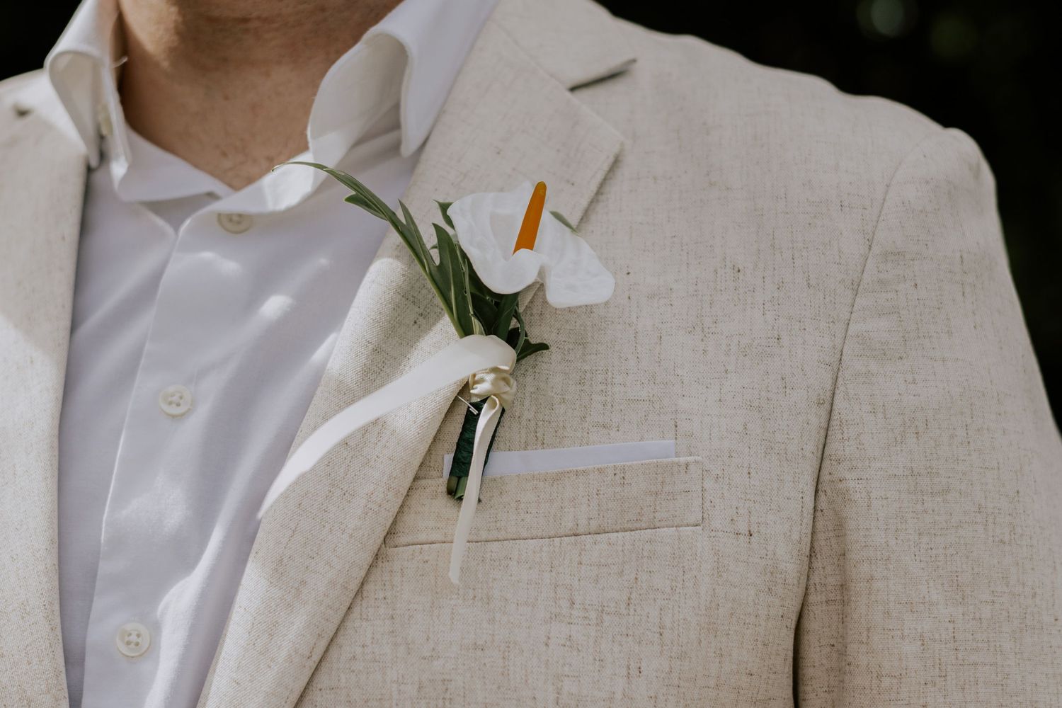 Groom wears beige linen suit with white calla lily boutonniere and white pocket square.
Sarasota Wedding Photographer