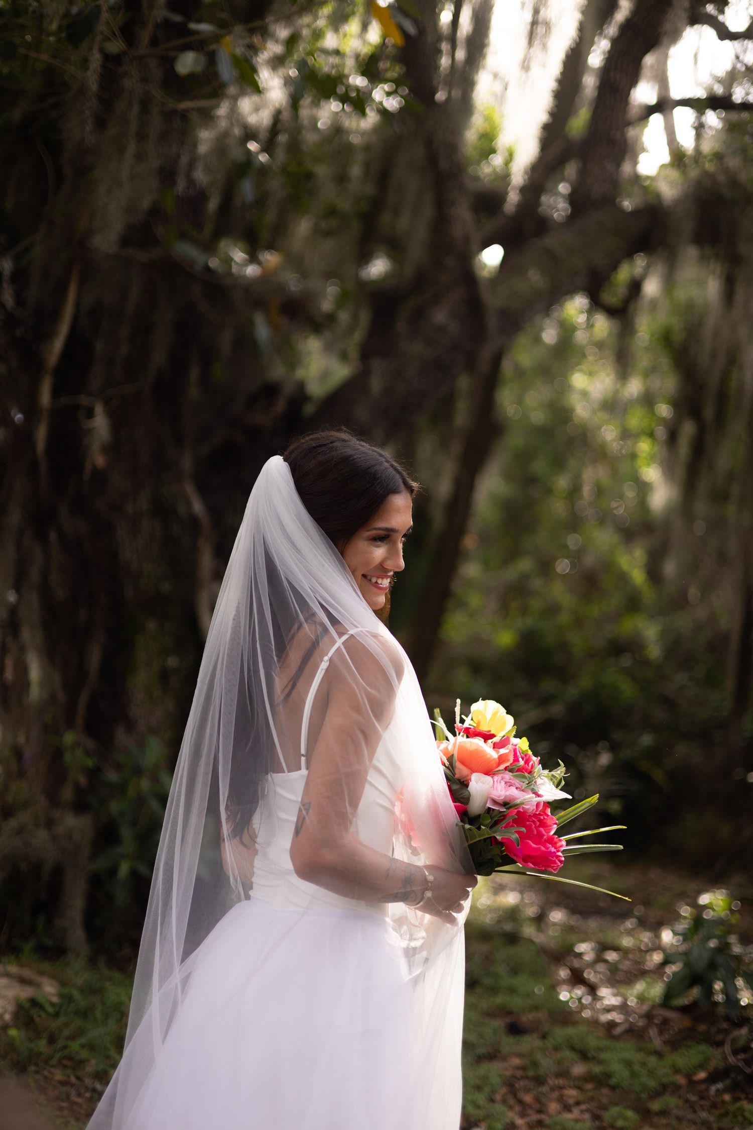 a bride holding her bouquet in front of mature oak trees in Okeechobee fl