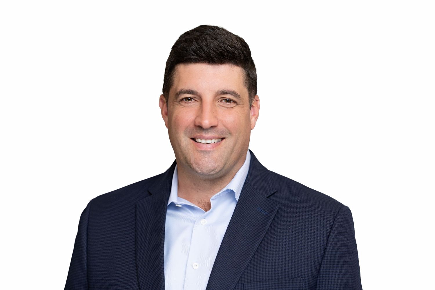 Professional headshot of a smiling businessman in a navy blazer and light blue shirt against a white background.