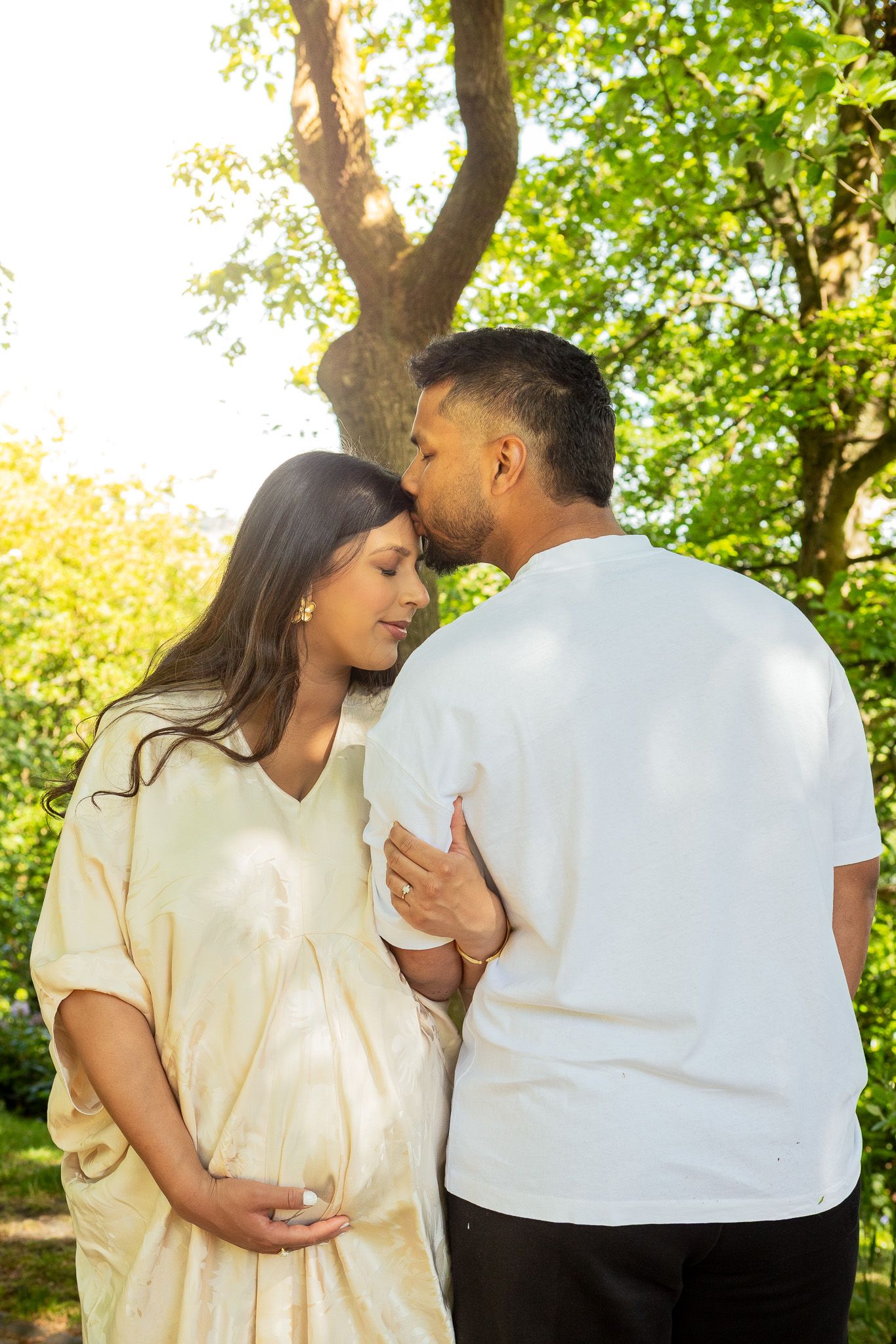 Expectant mother holding bump during outdoor maternity photoshoot in Huddersfield countryside