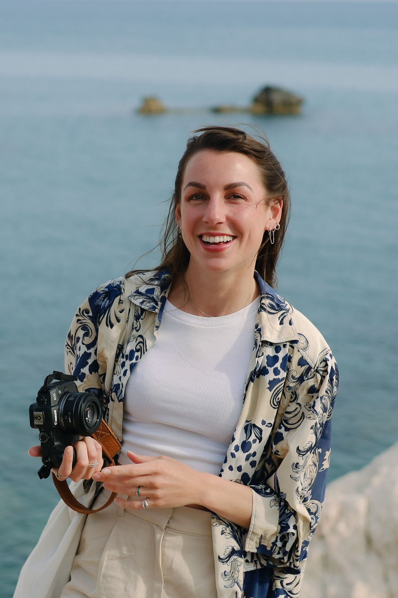 Sfeerimpressie van fotograaf atelier ROSA met camera bij de oceaan, gespecialiseerd in bruiloften vol emotie en onvergetelijke momenten.