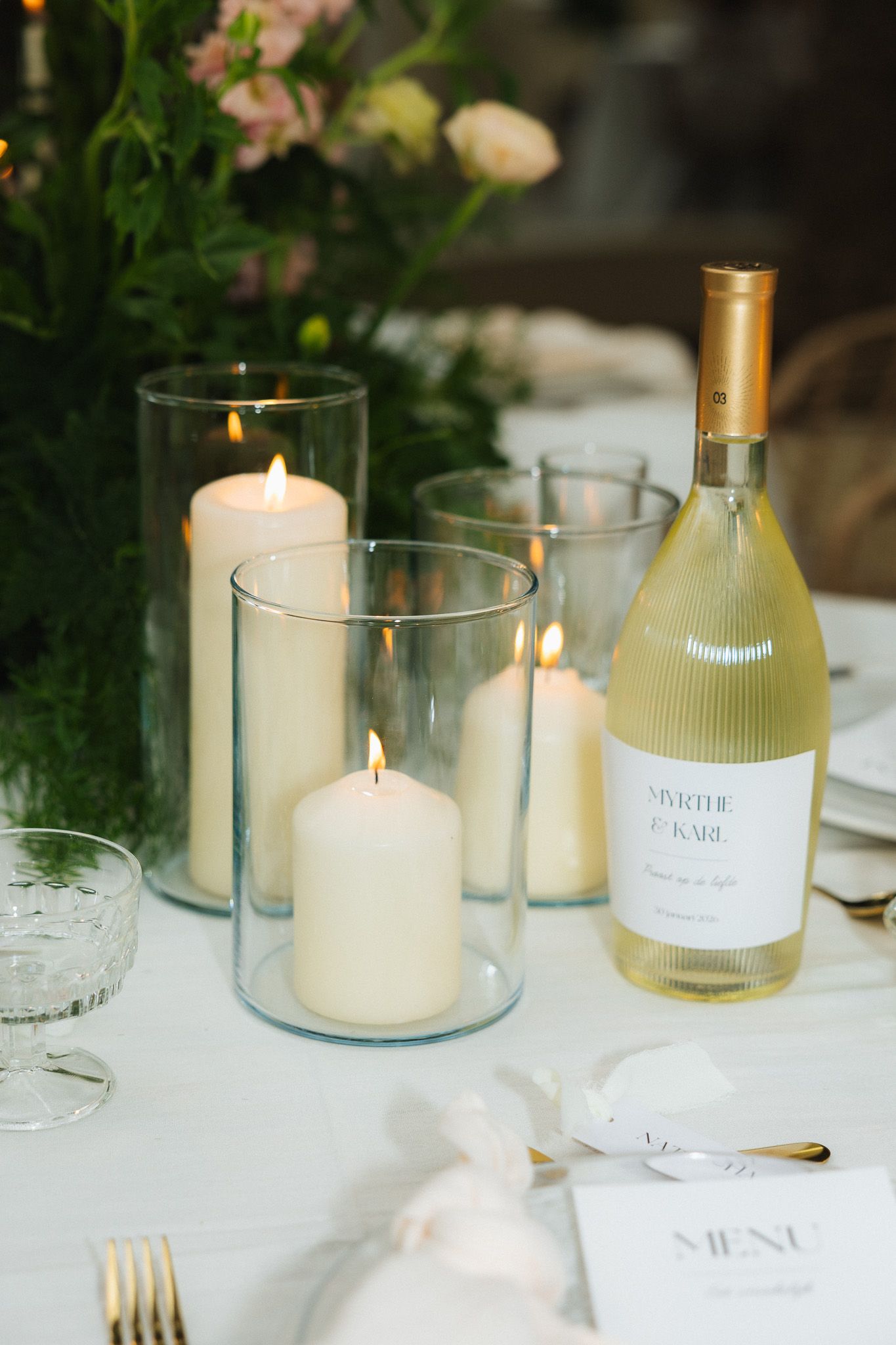Elegante tafelstyling voor een huwelijksreceptie met dinerkaarsen en wijn; verfijnde details van een winterbruiloft