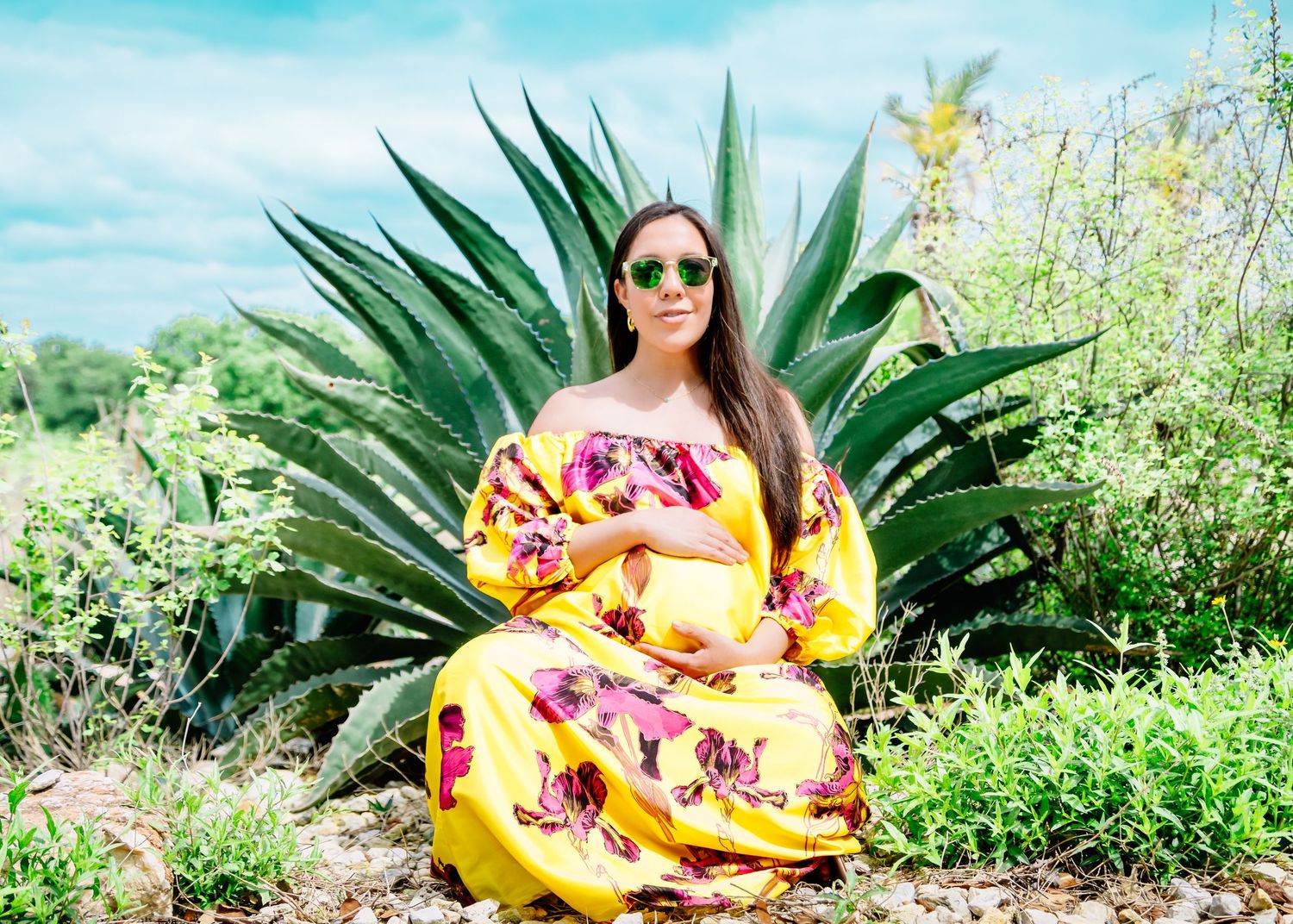 Yellow dress flows elegantly against desert landscape with agave plants.