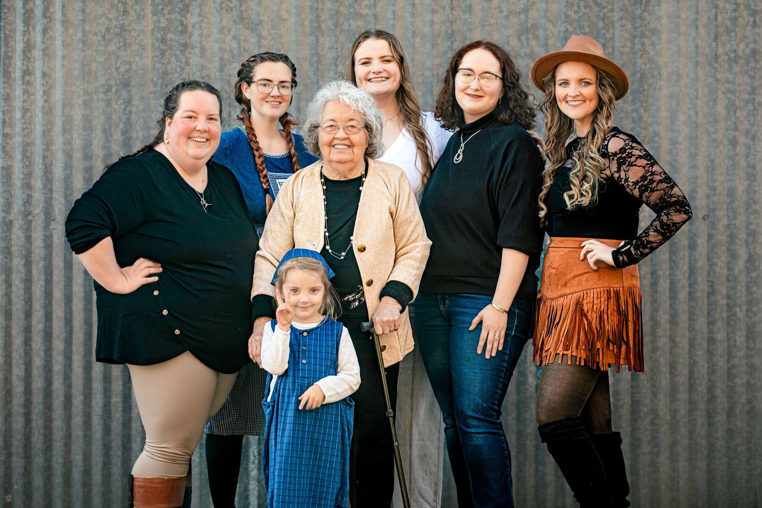 Group portrait against industrial corrugated metal wall background.