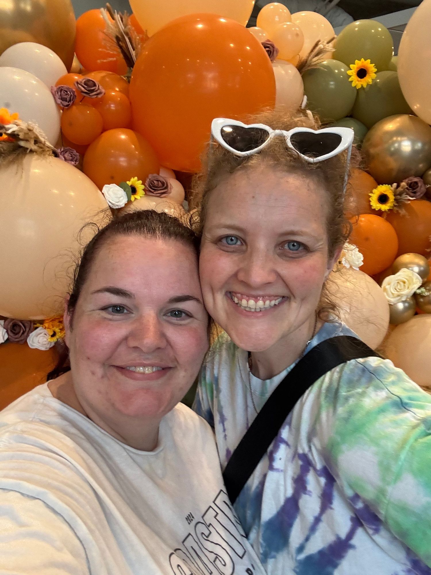 Festive balloon display with orange, white and sunflower decorations.