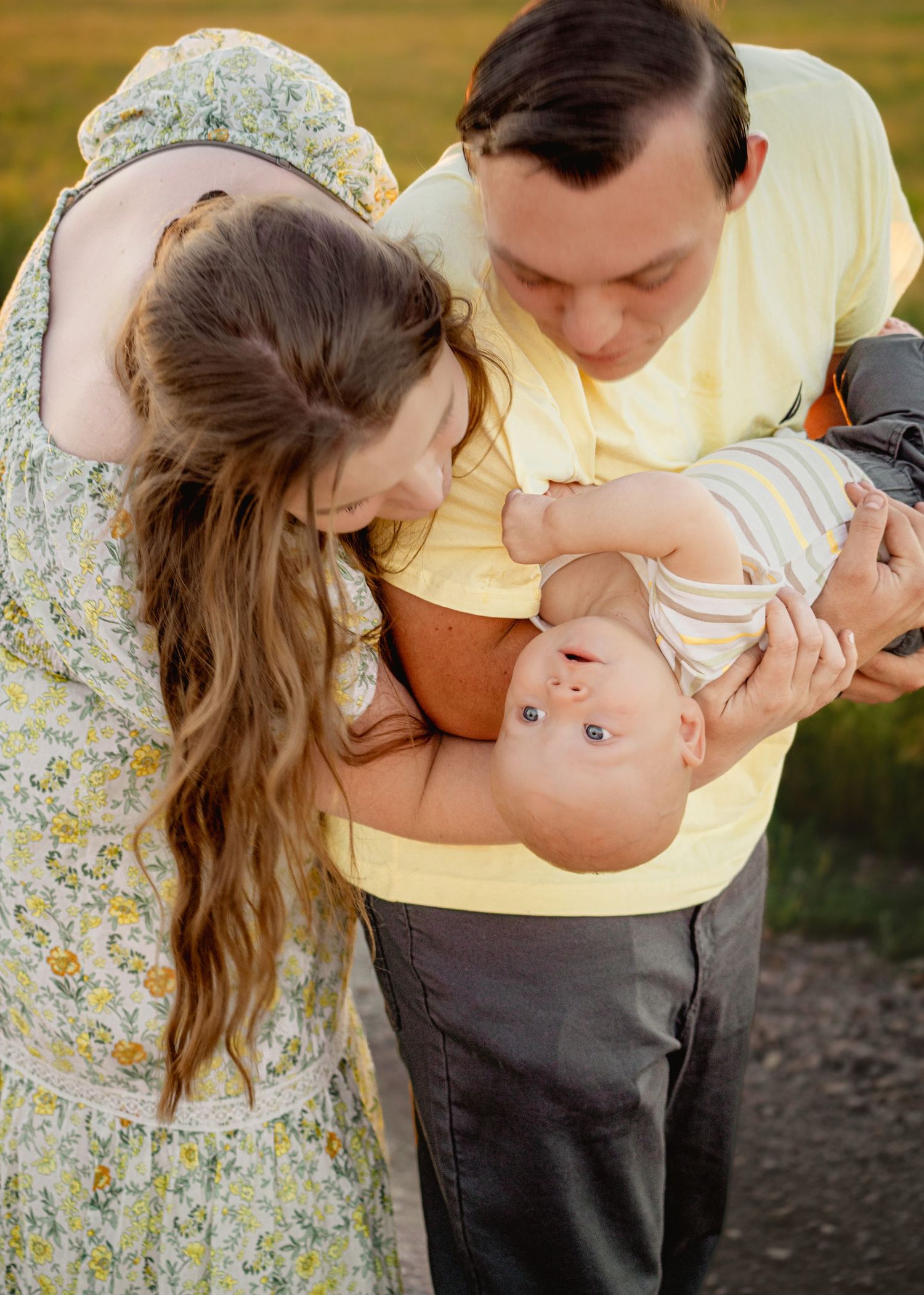 Couple in casual attire shares intimate moments during outdoor sunset photoshoot.