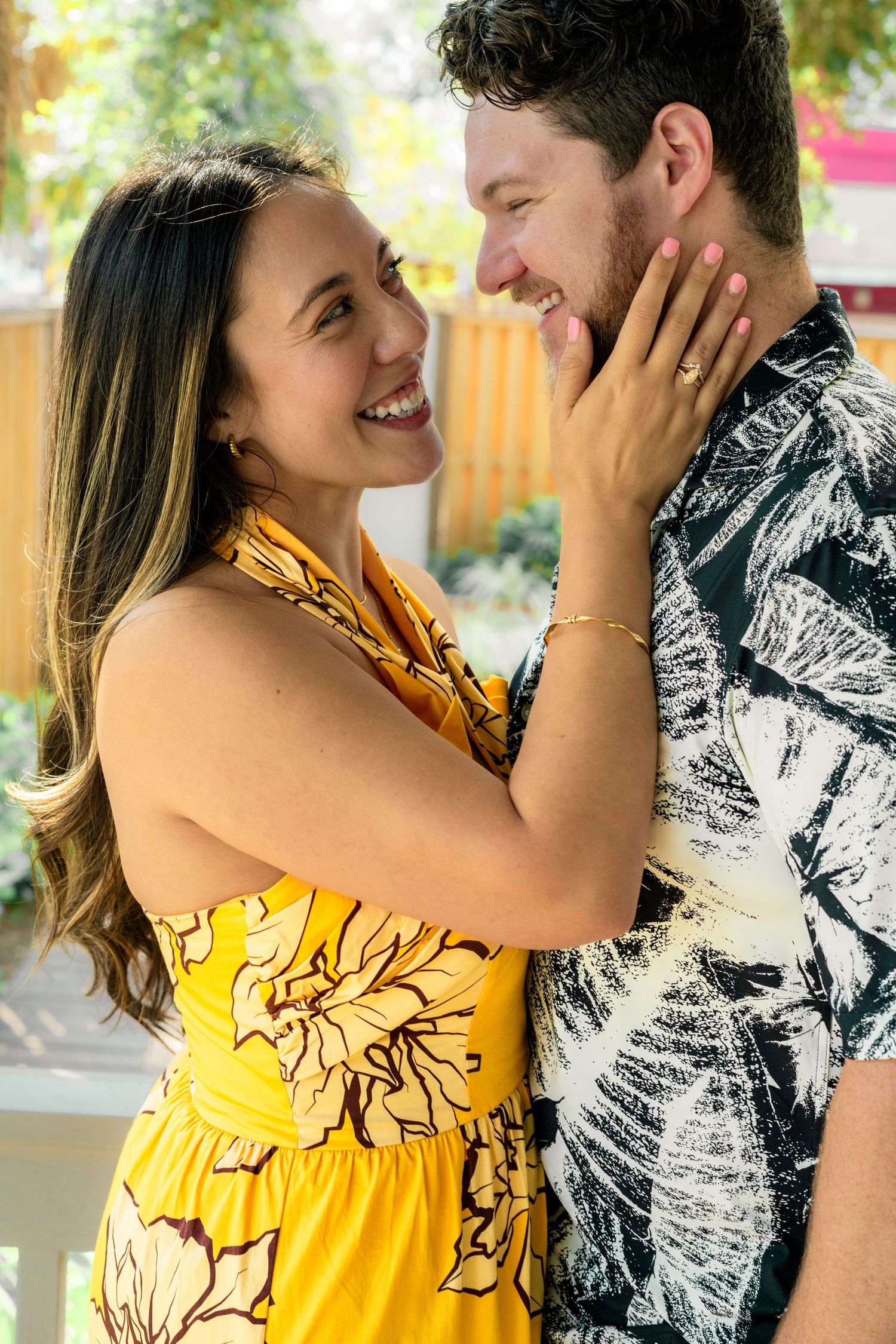 Couple embracing in yellow and black outfits against outdoor background.