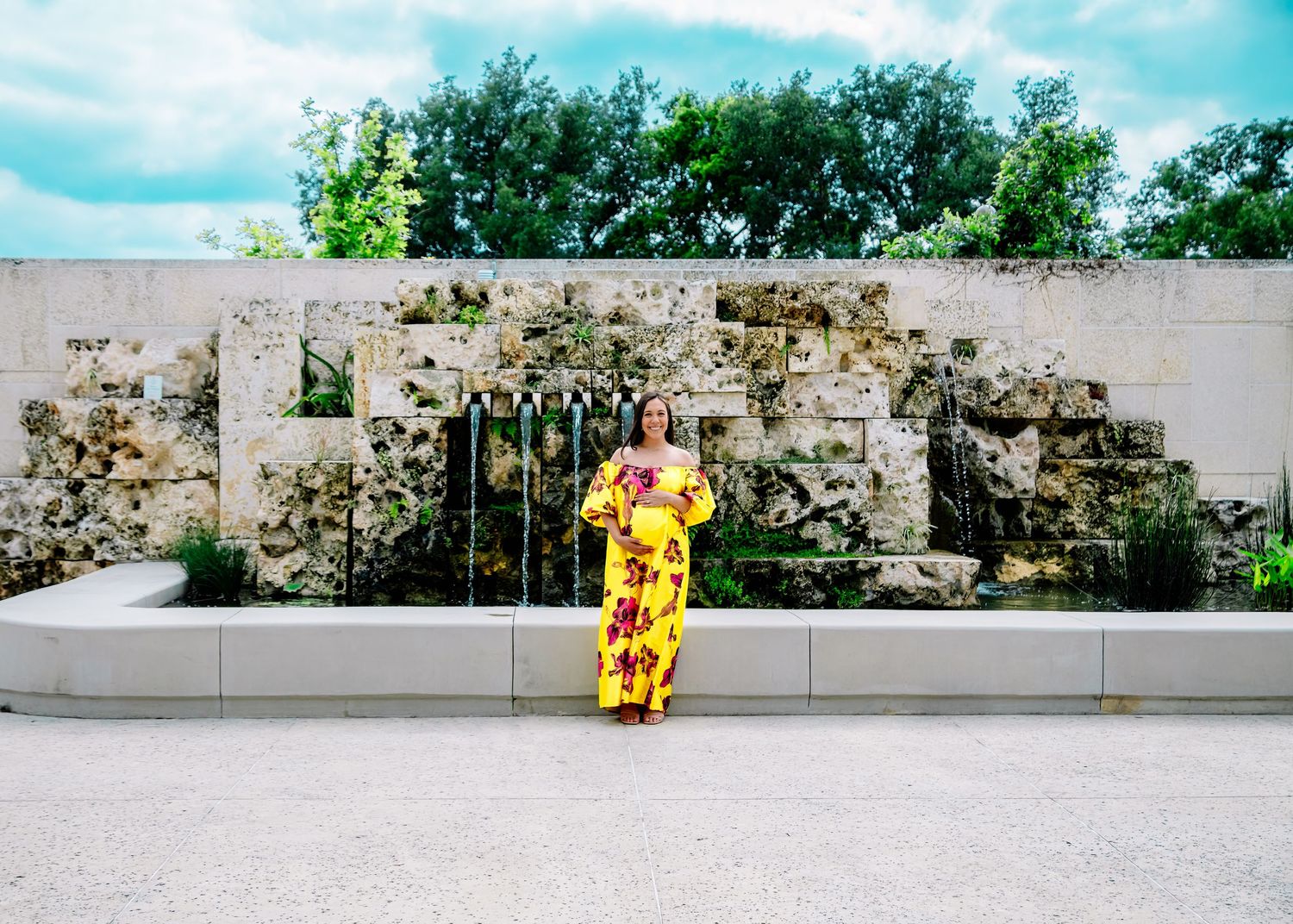 Yellow dress creates striking contrast against minimalist concrete wall setting.