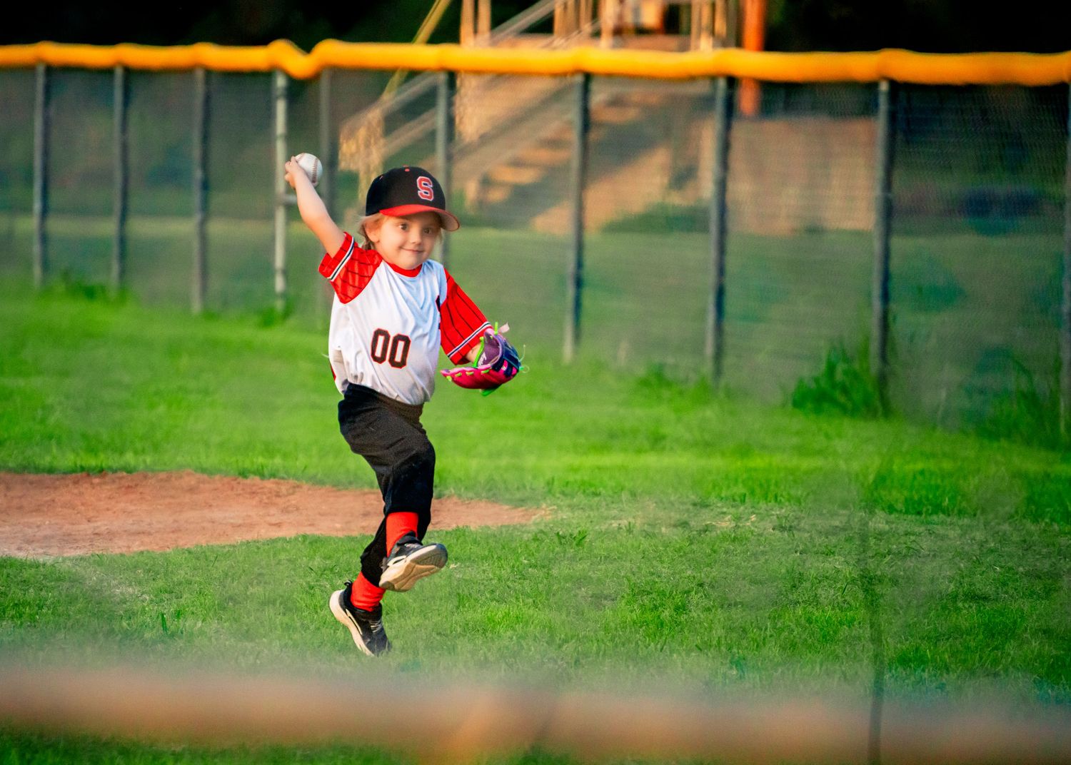 Baseball players run between bases during a youth league game.