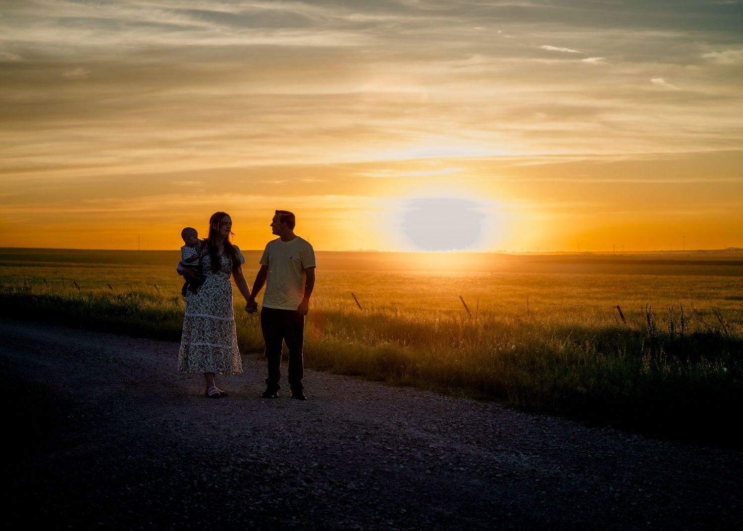 Beautiful sunset silhouettes against an orange sky over a rural landscape.