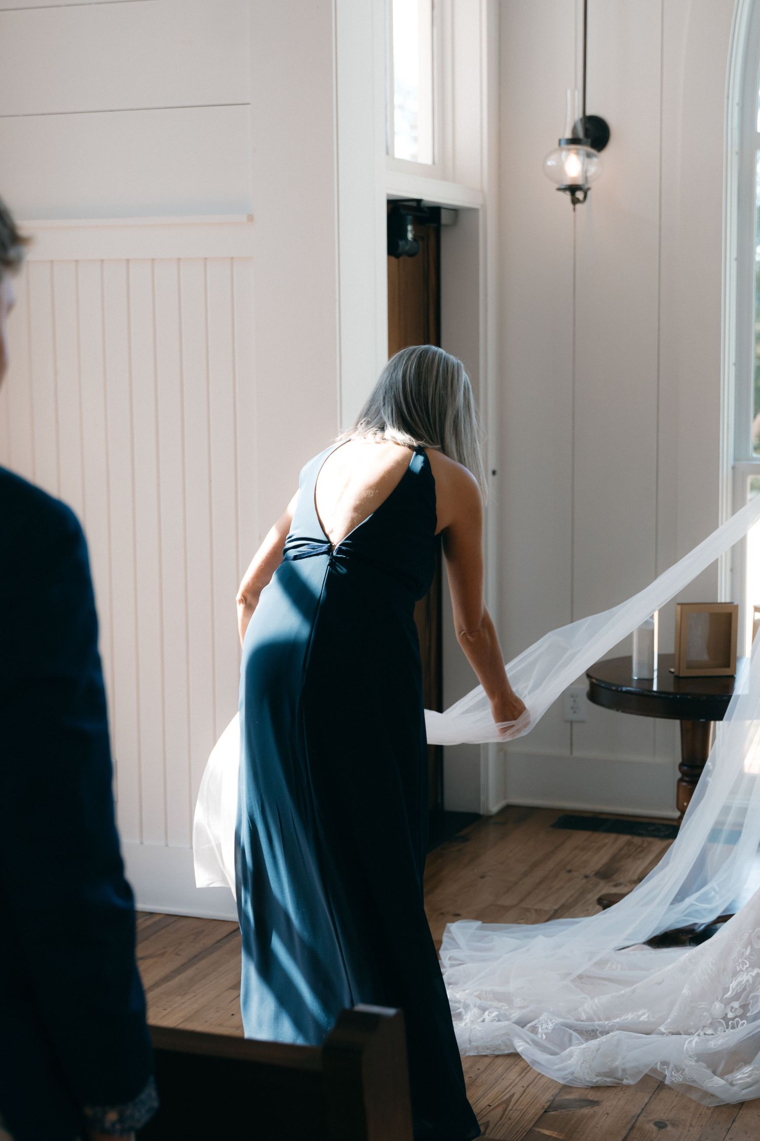 Long flowing white dress train trailing across wooden floor.