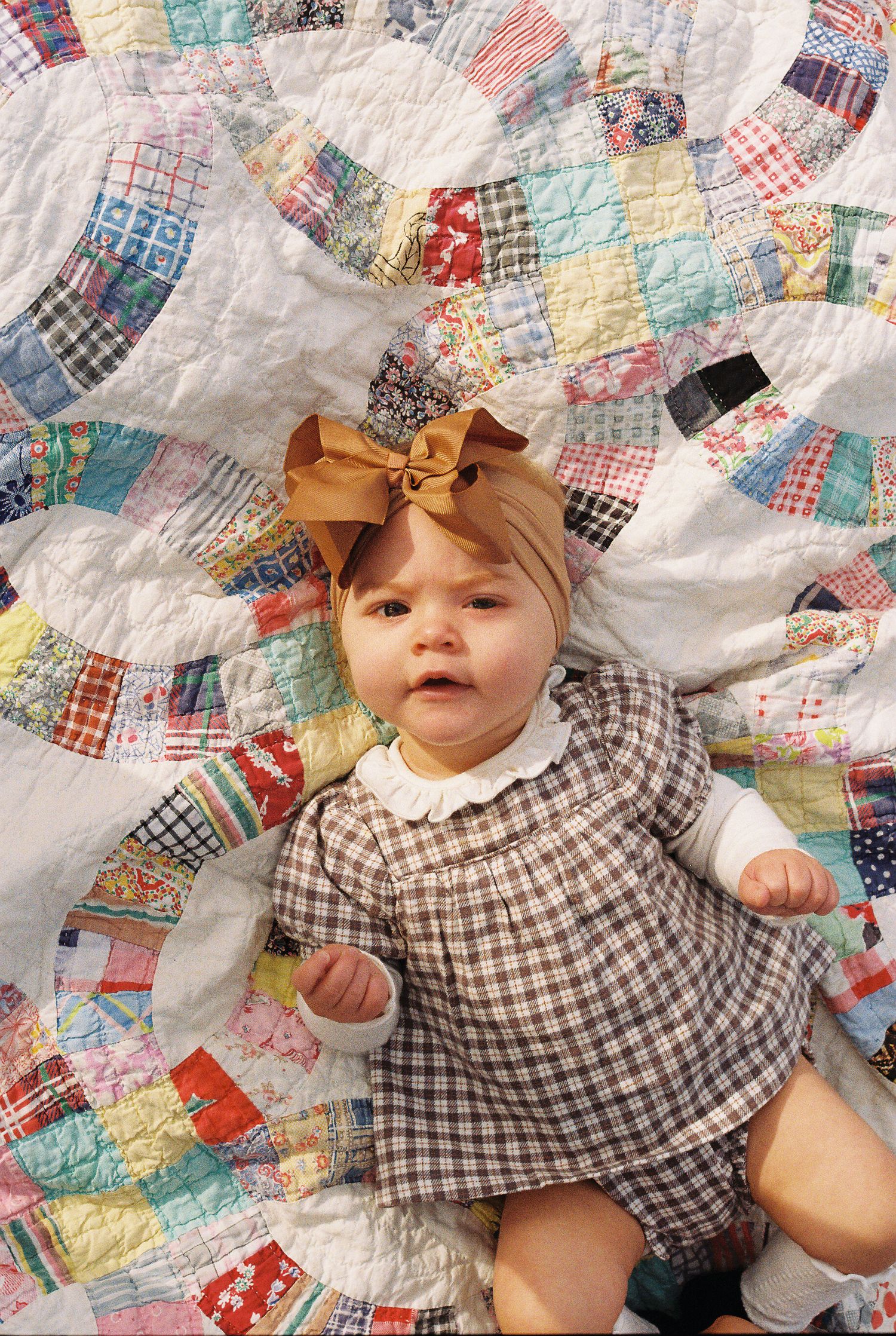 Vintage patchwork quilt with colorful fabric squares arranged in a double wedding ring pattern.