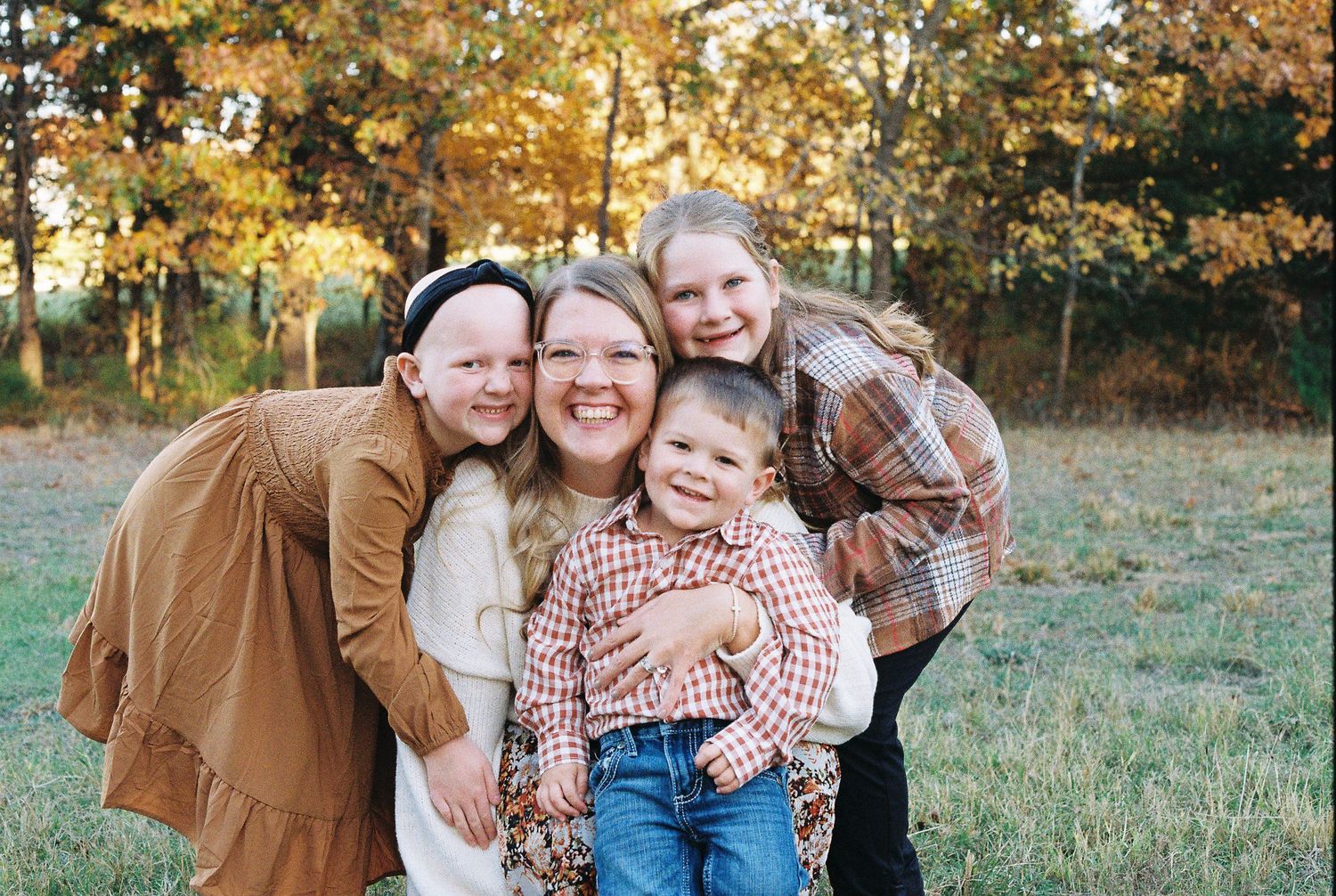 Group portrait in autumn field with warm earth-toned clothing.